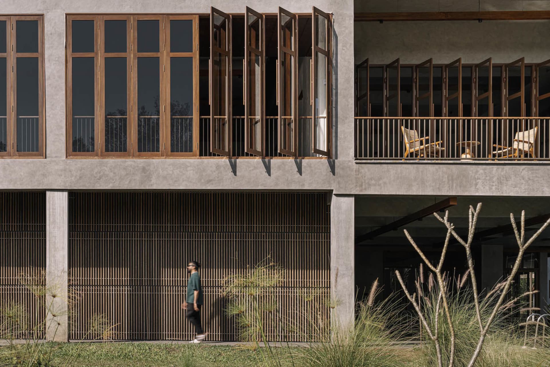 Modern building exterior featuring concrete, glass, and wooden elements.