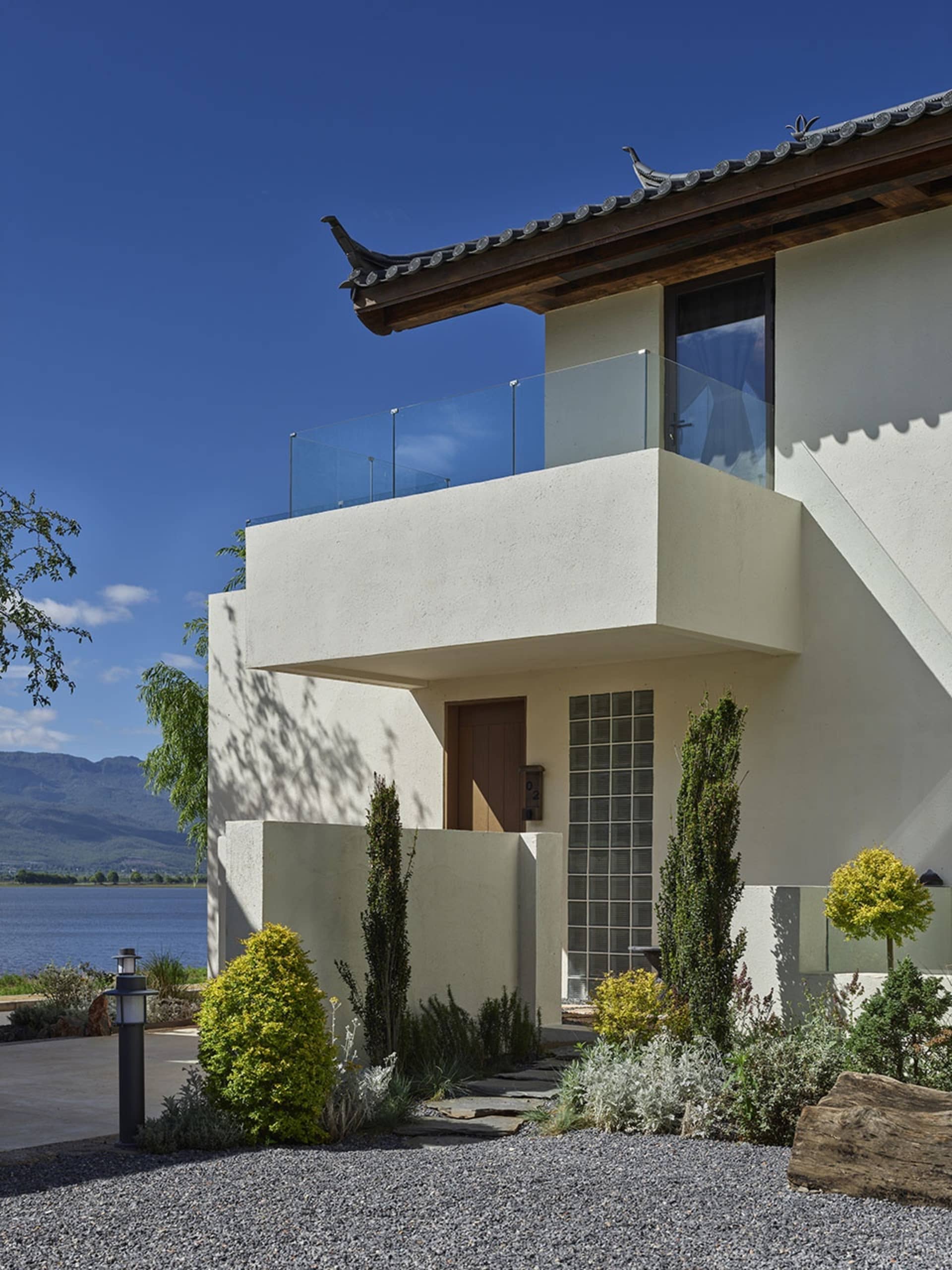 The exterior of a modern house featuring a concrete façade and glass elements.
