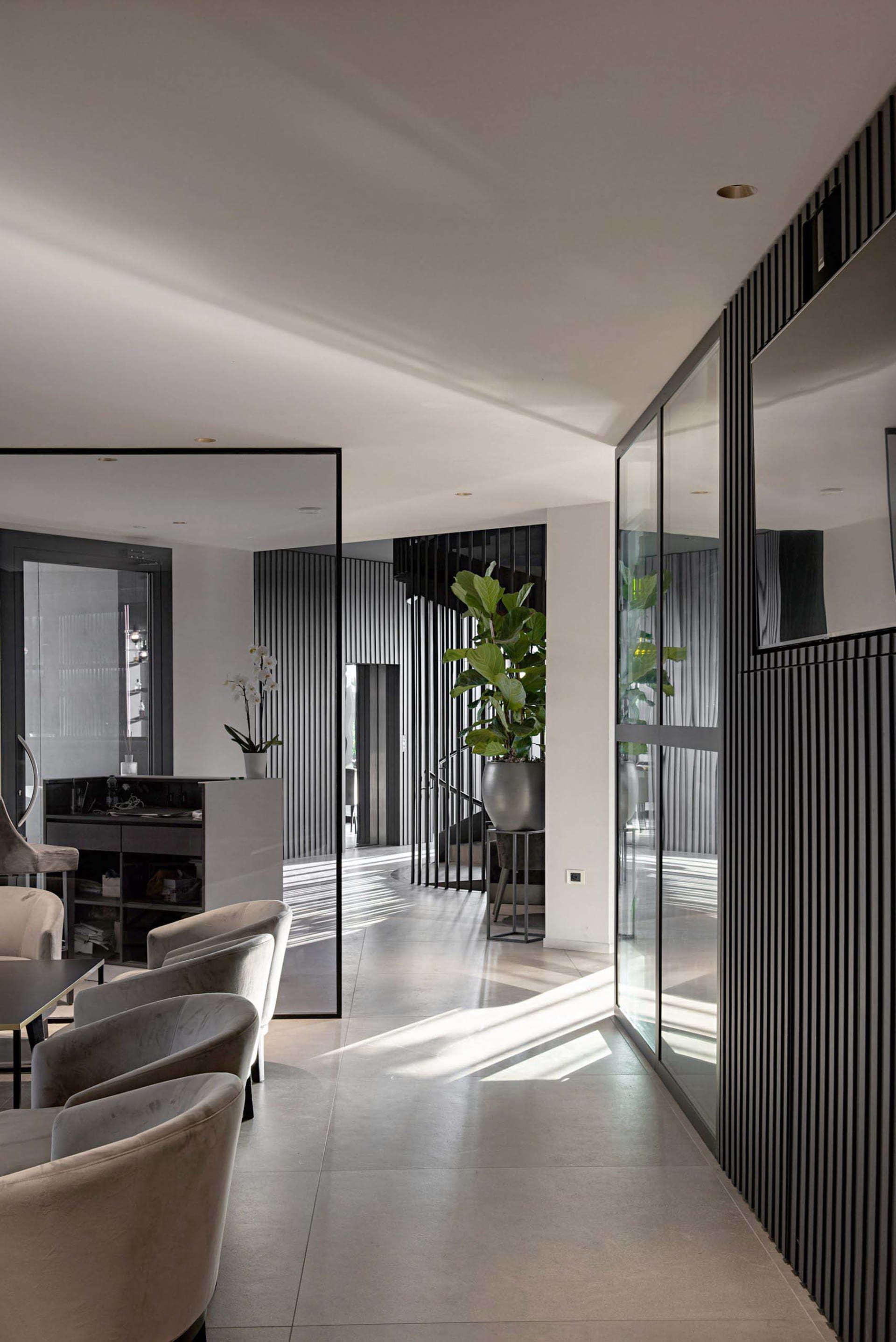 A modern interior space featuring concrete, glass, and metallic elements.