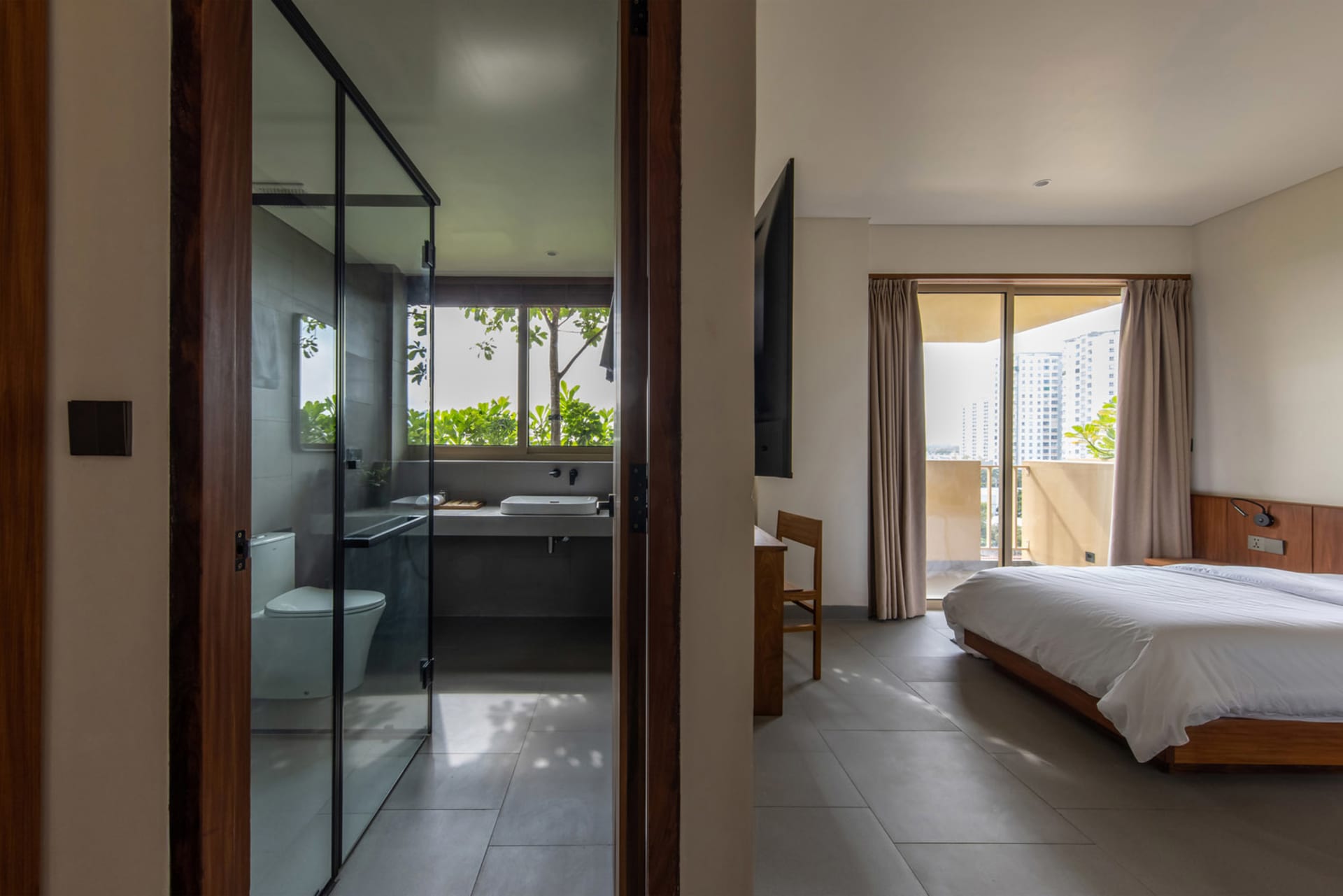 Modern minimalist bedroom featuring concrete and glass materials