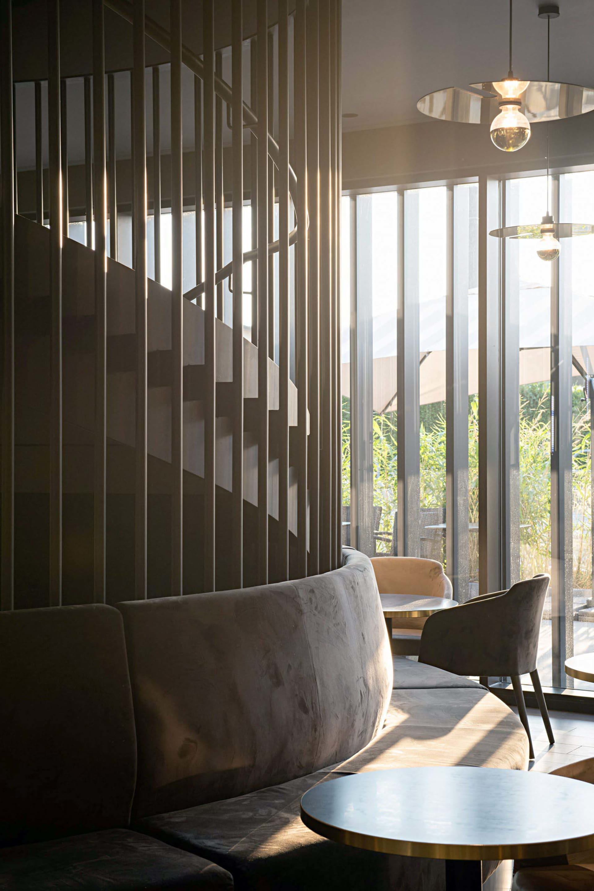 A cozy cafe bar with velvet seating and glass windows