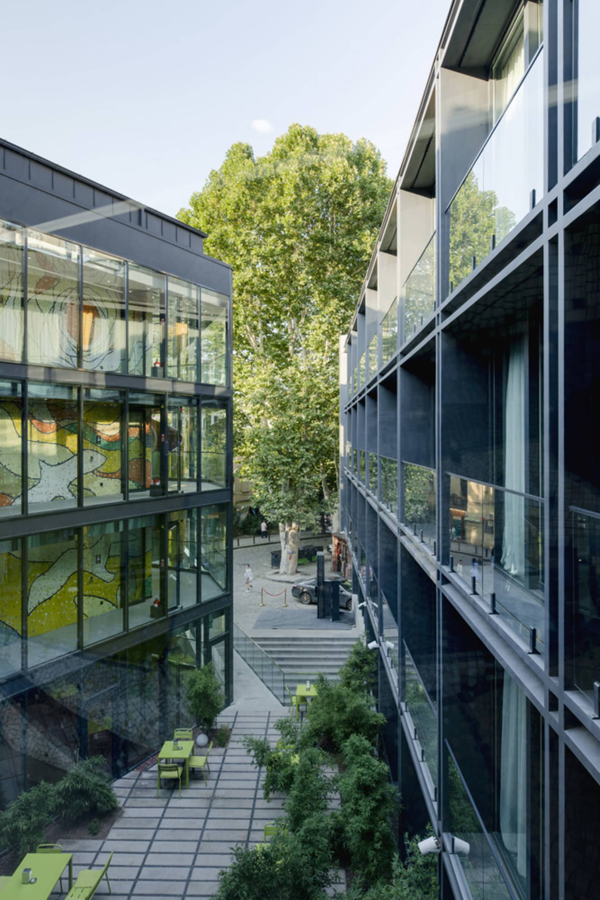 戶外庭院，現代玻璃建築與綠意植栽。