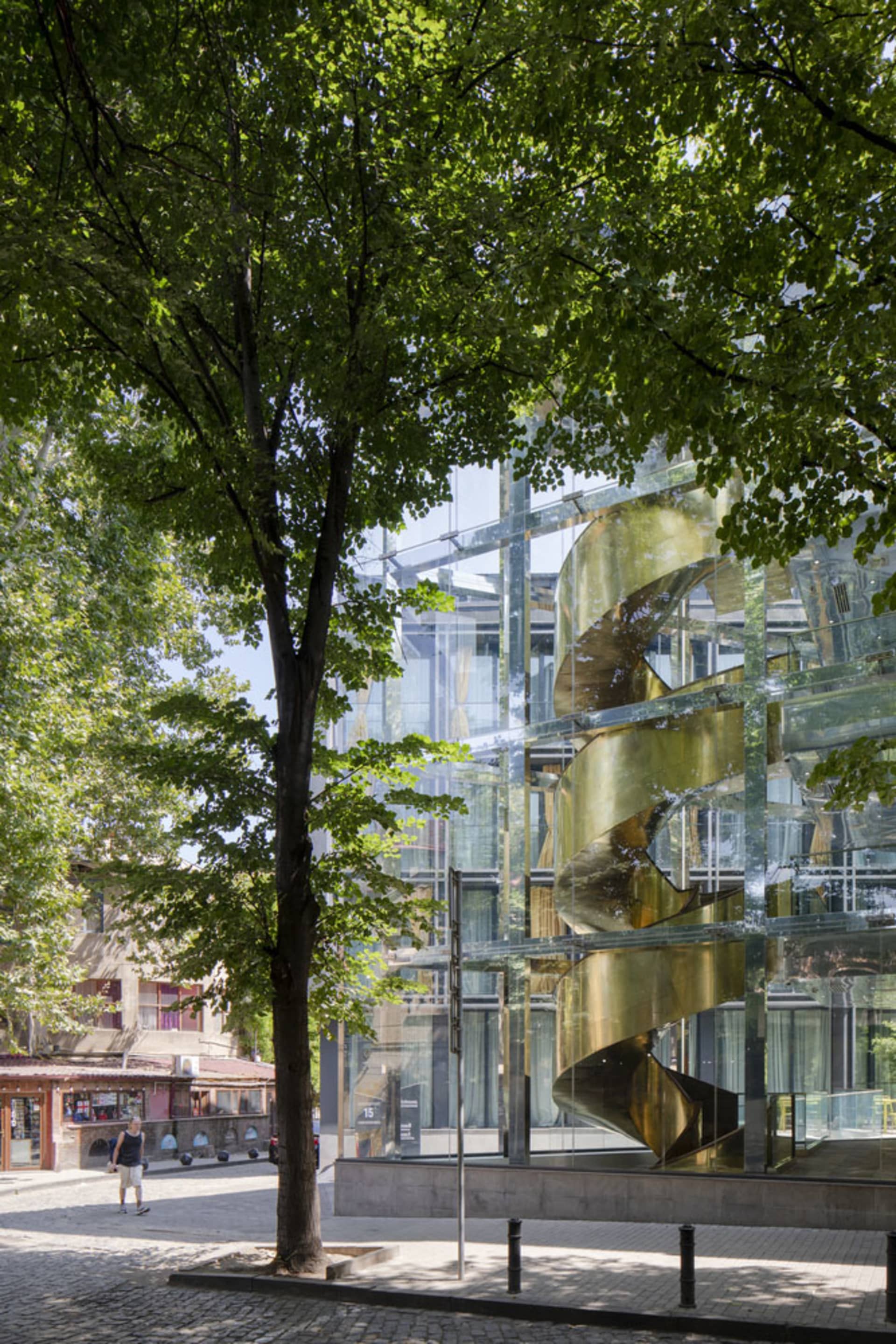 Modern building with glass facade and spiral staircase.