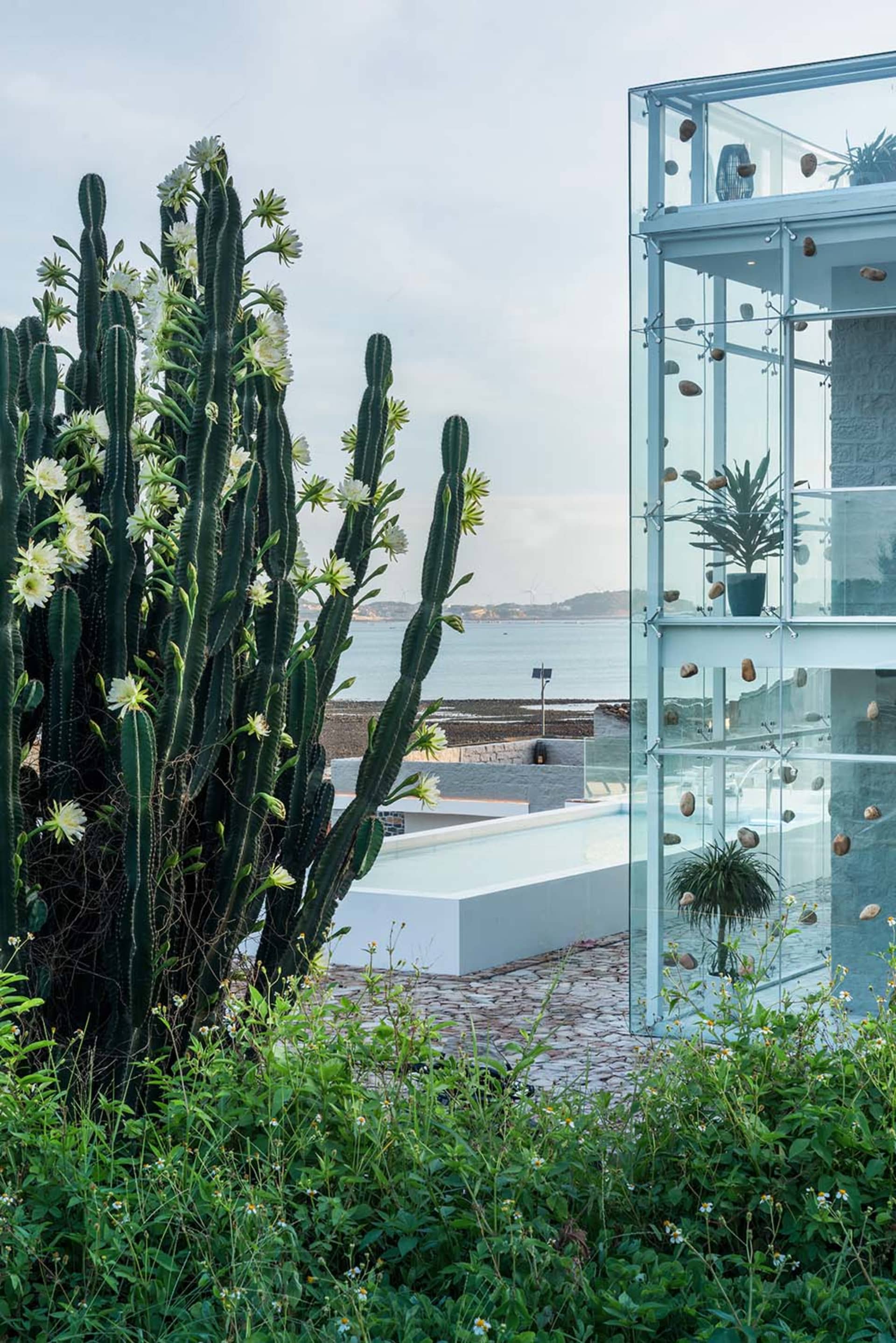 A modern residential casino with glass walls overlooking the ocean.