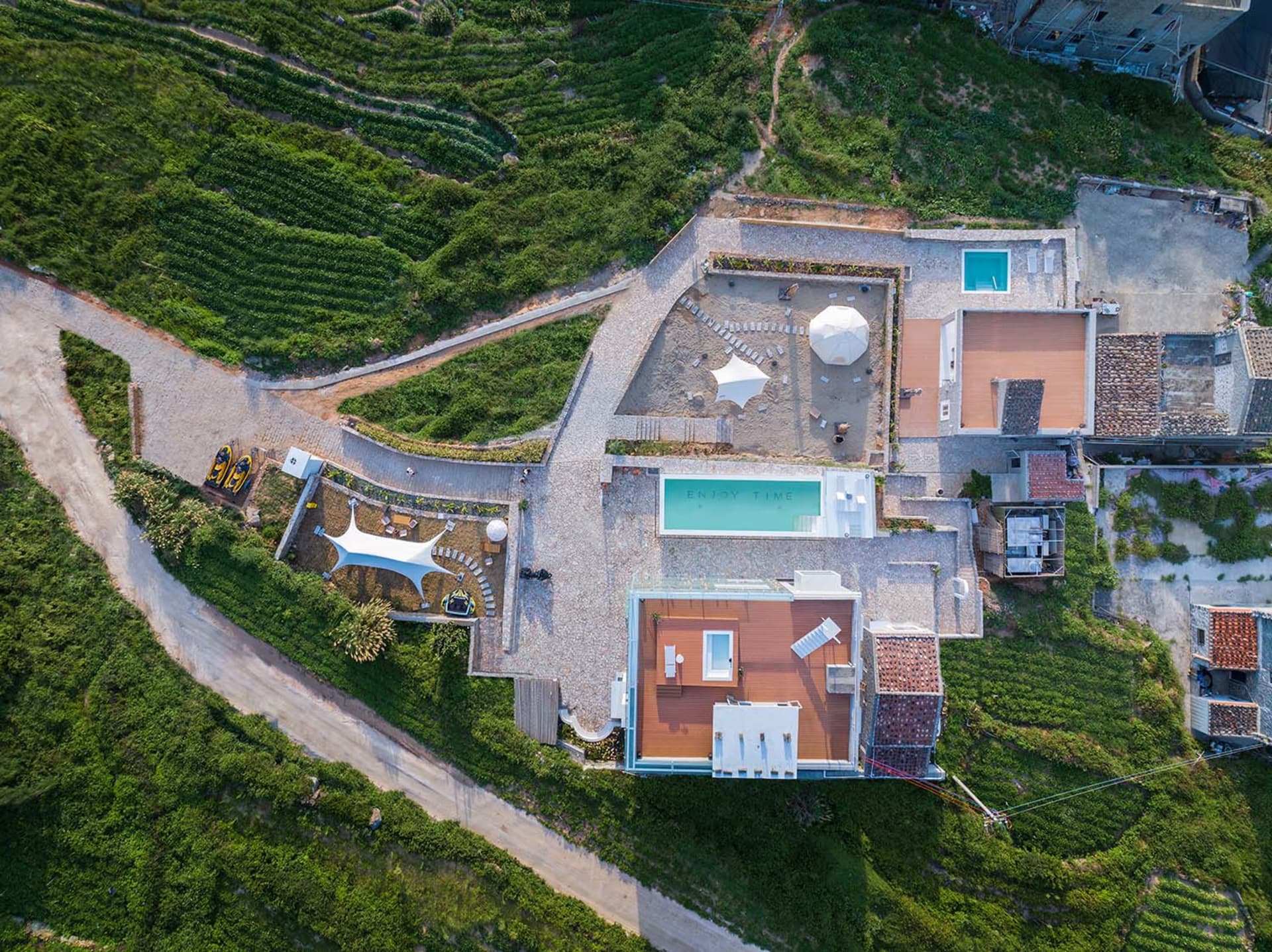 俯瞰現代住宅屋頂露台，採用混凝土與金屬元素，搭配玻璃游泳池與休憩區