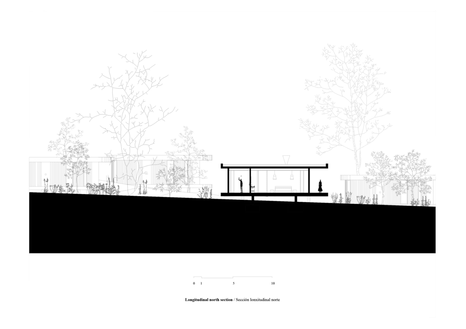 A modern building with a metal roof and sleek lines, surrounded by greenery.