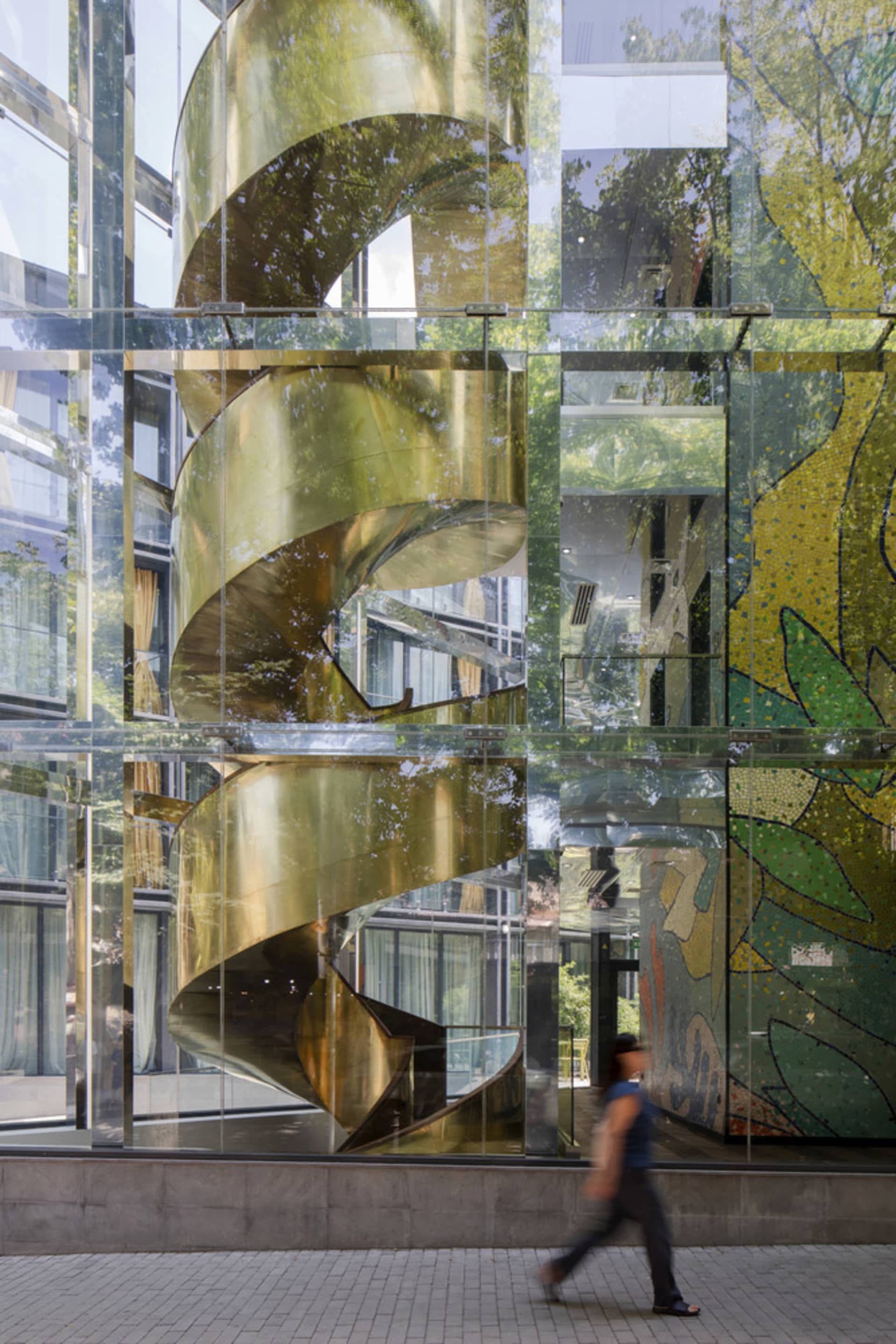 A modern building with a spiral staircase made of glass.