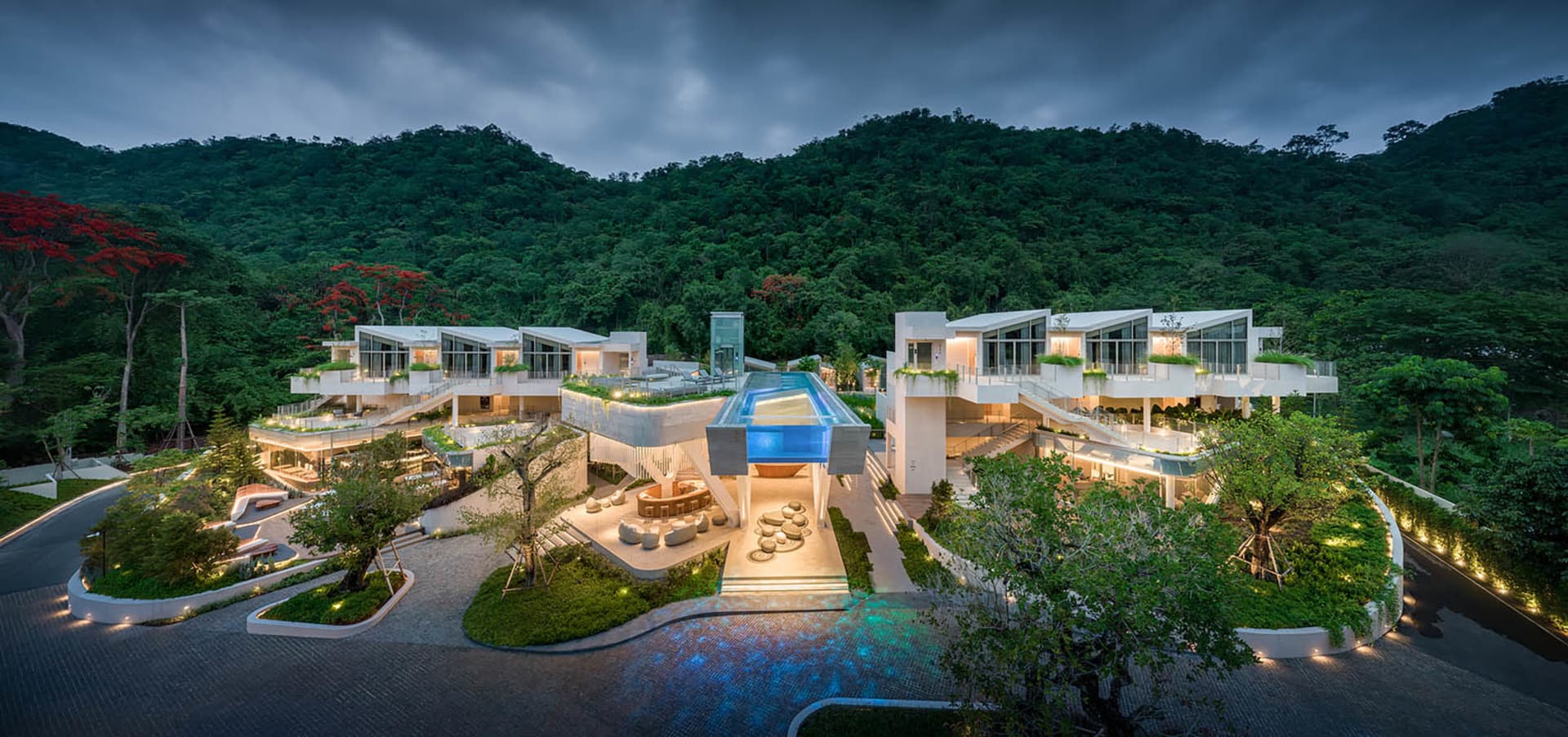 An elevated modern residential community with concrete floors, glass walls, and wooden accents.