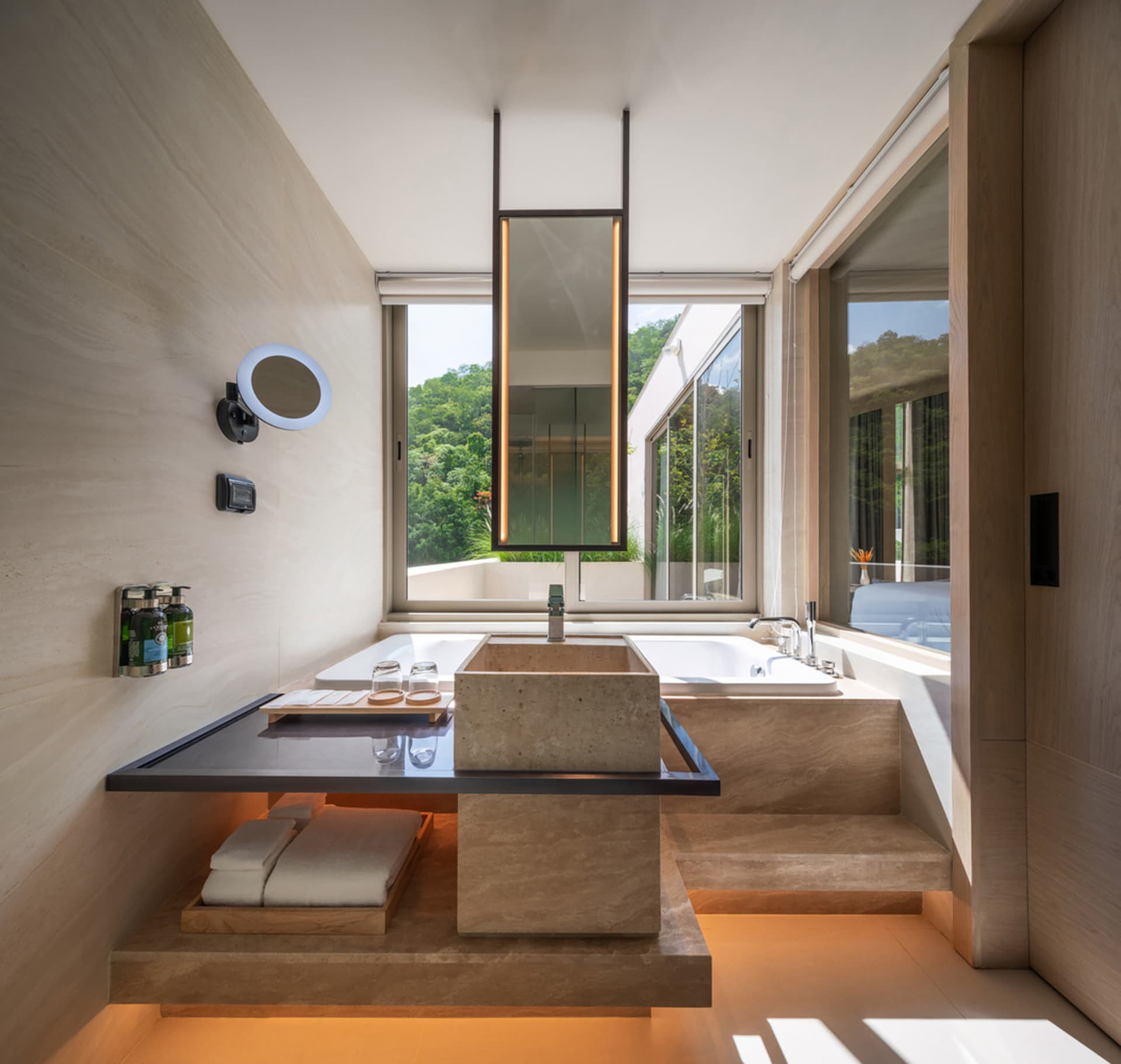Modern bathroom with marble sink, tub, and floor, surrounded by large windows.