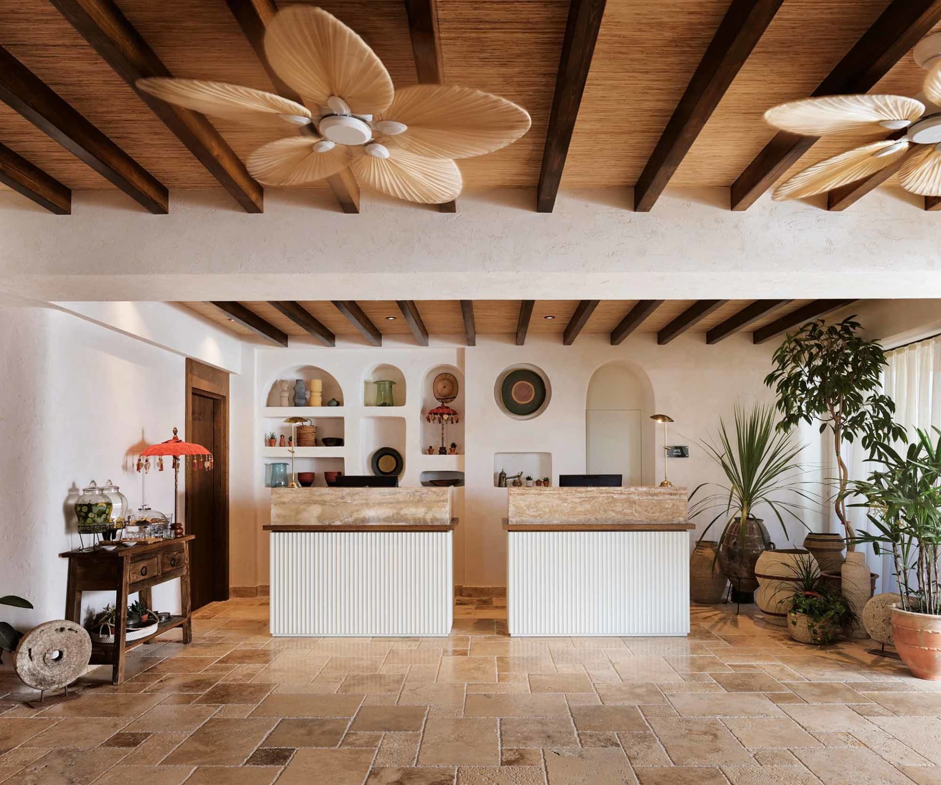 A modern reception desk with a stone countertop and wooden beam ceiling.