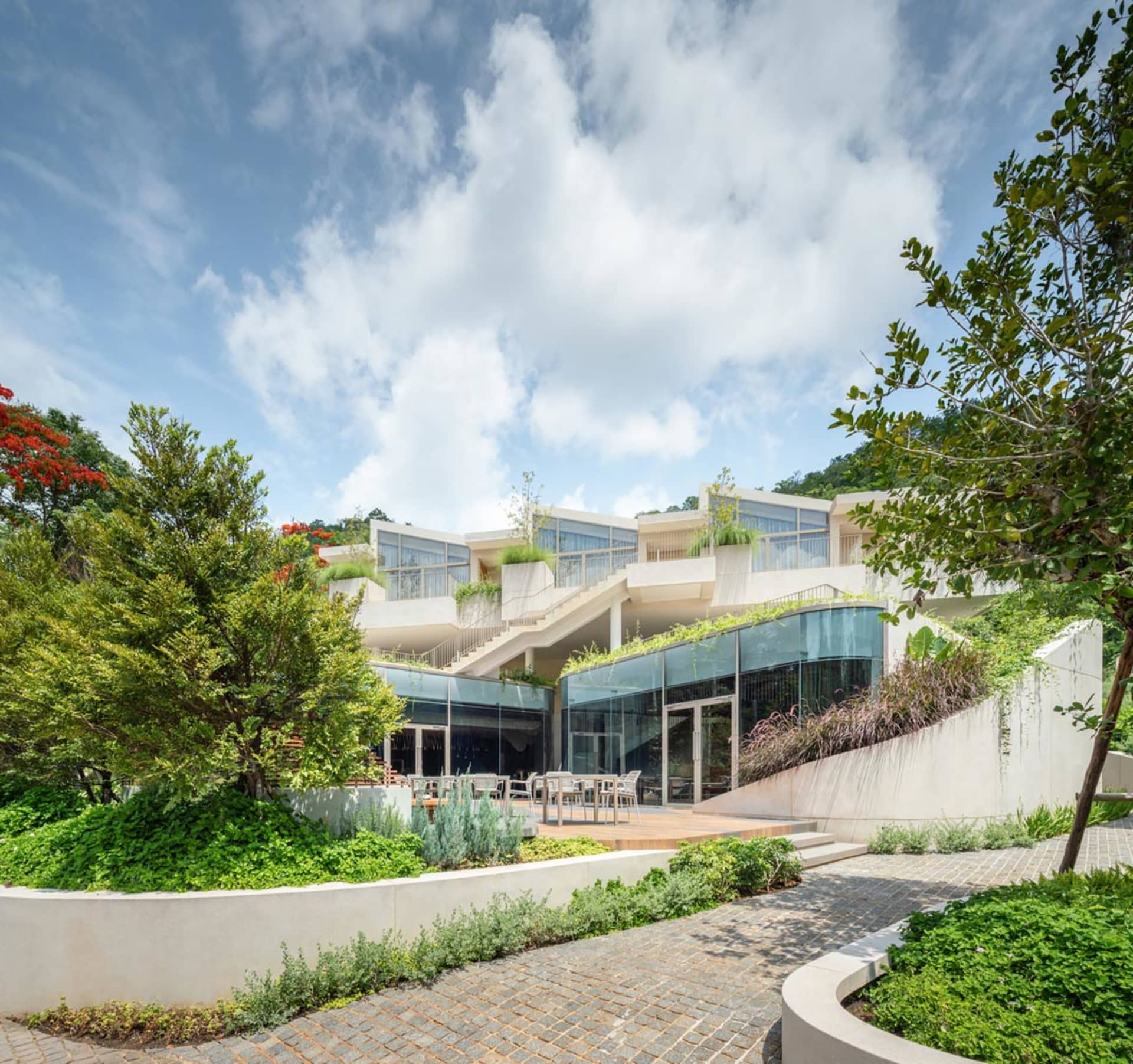 現代住宅建築採用白色混凝土外觀,搭配大面窗與綠意植栽。