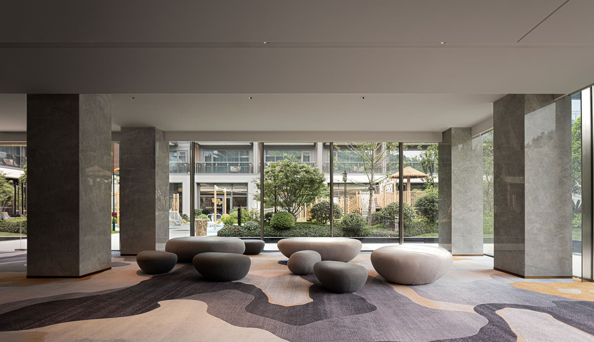 A modern, contemporary lobby featuring concrete elements and a textured surface