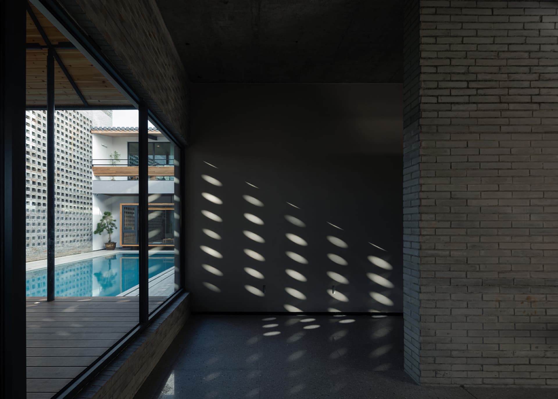 A minimalist interior featuring a brick and concrete art installation.