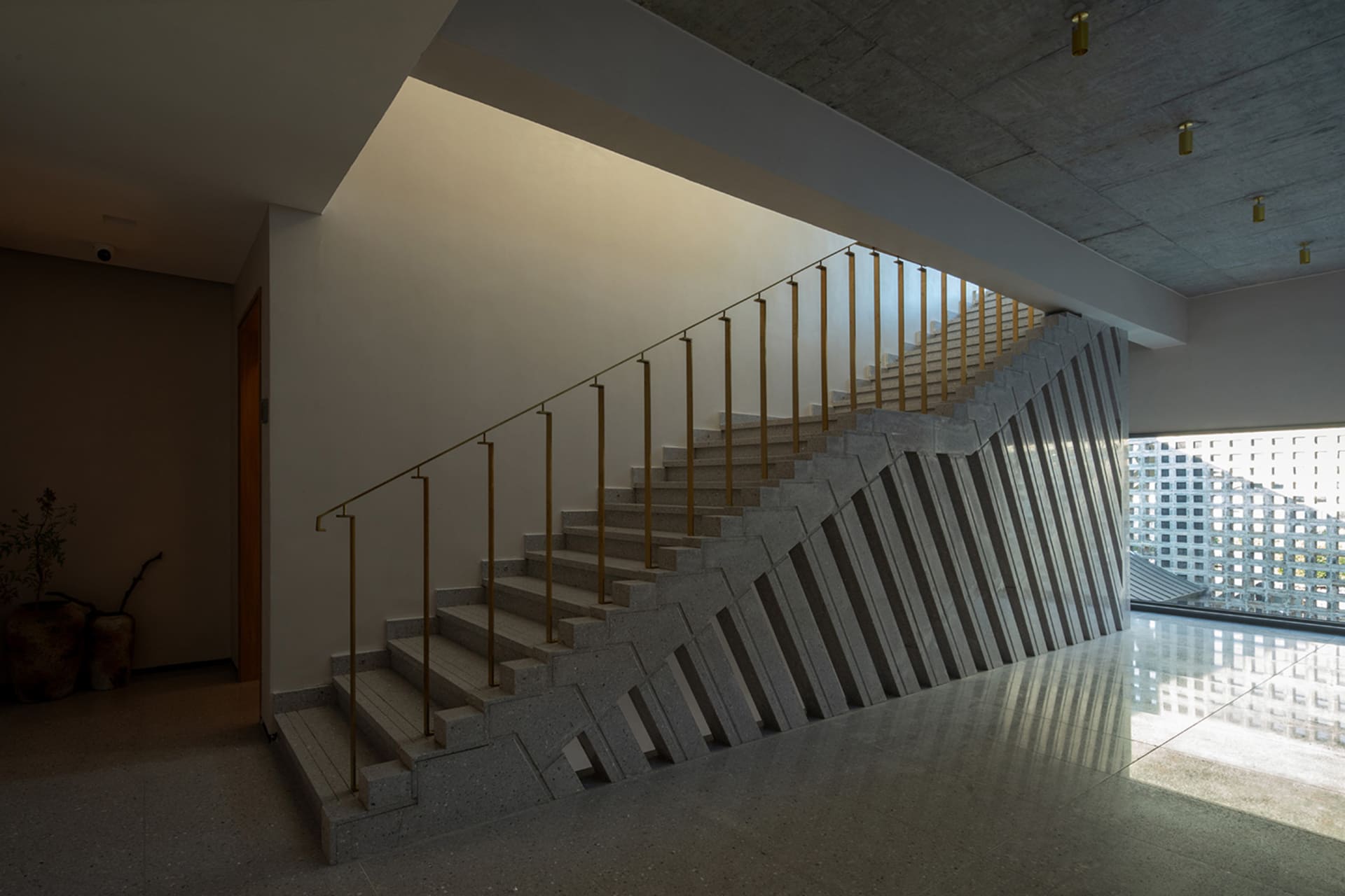 Staircase with concrete steps and yellow handrails in a modern architectural space.