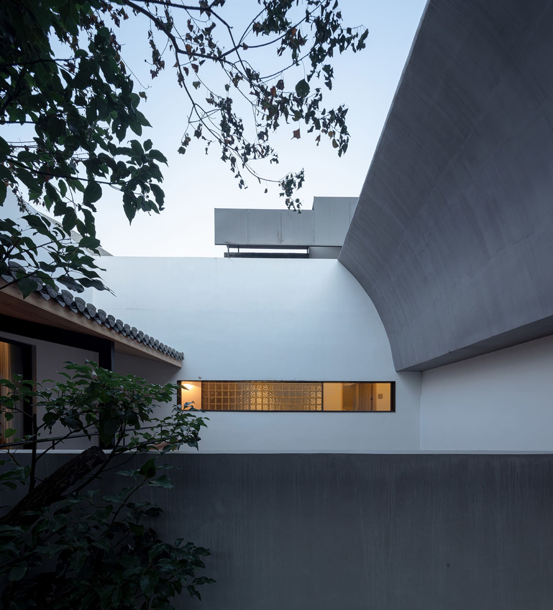 Modern residential building exterior with concrete walls and a geometric design.