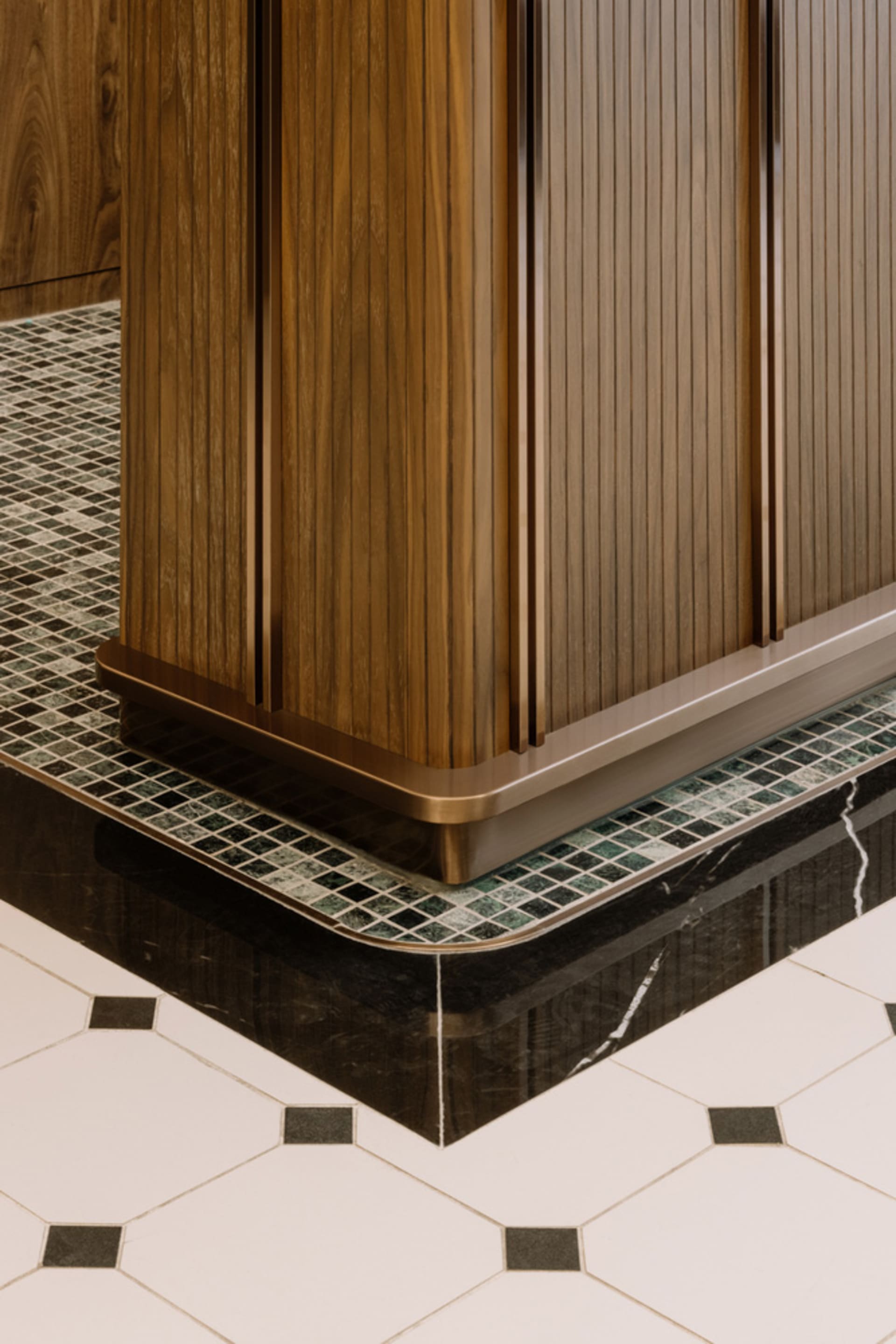 Modern kitchen with wooden cabinets, marble floor, and tiled accents.