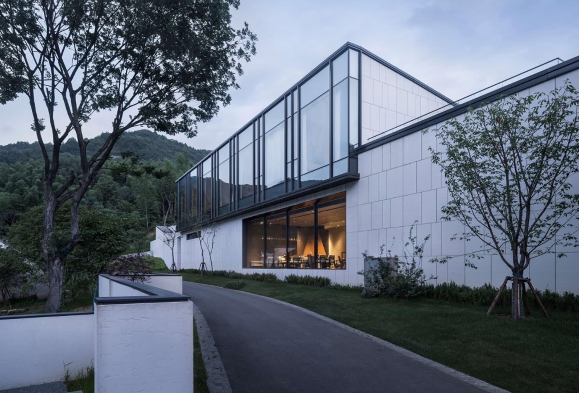 一座擁有玻璃牆與白色瓷磚外牆的現代住宅建築。