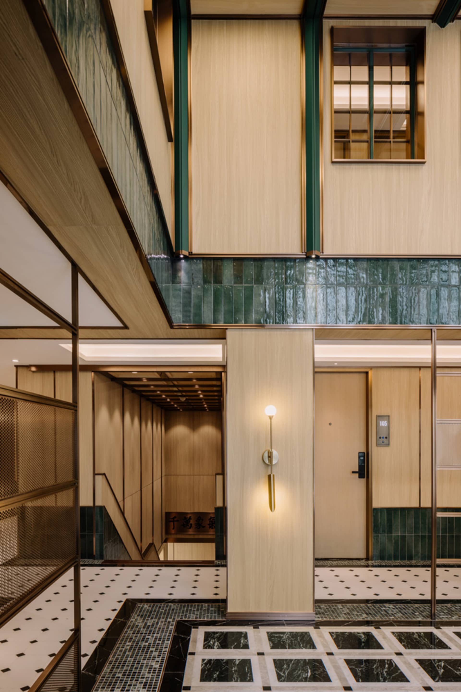 A modern lobby featuring marble walls and monochrome flooring.