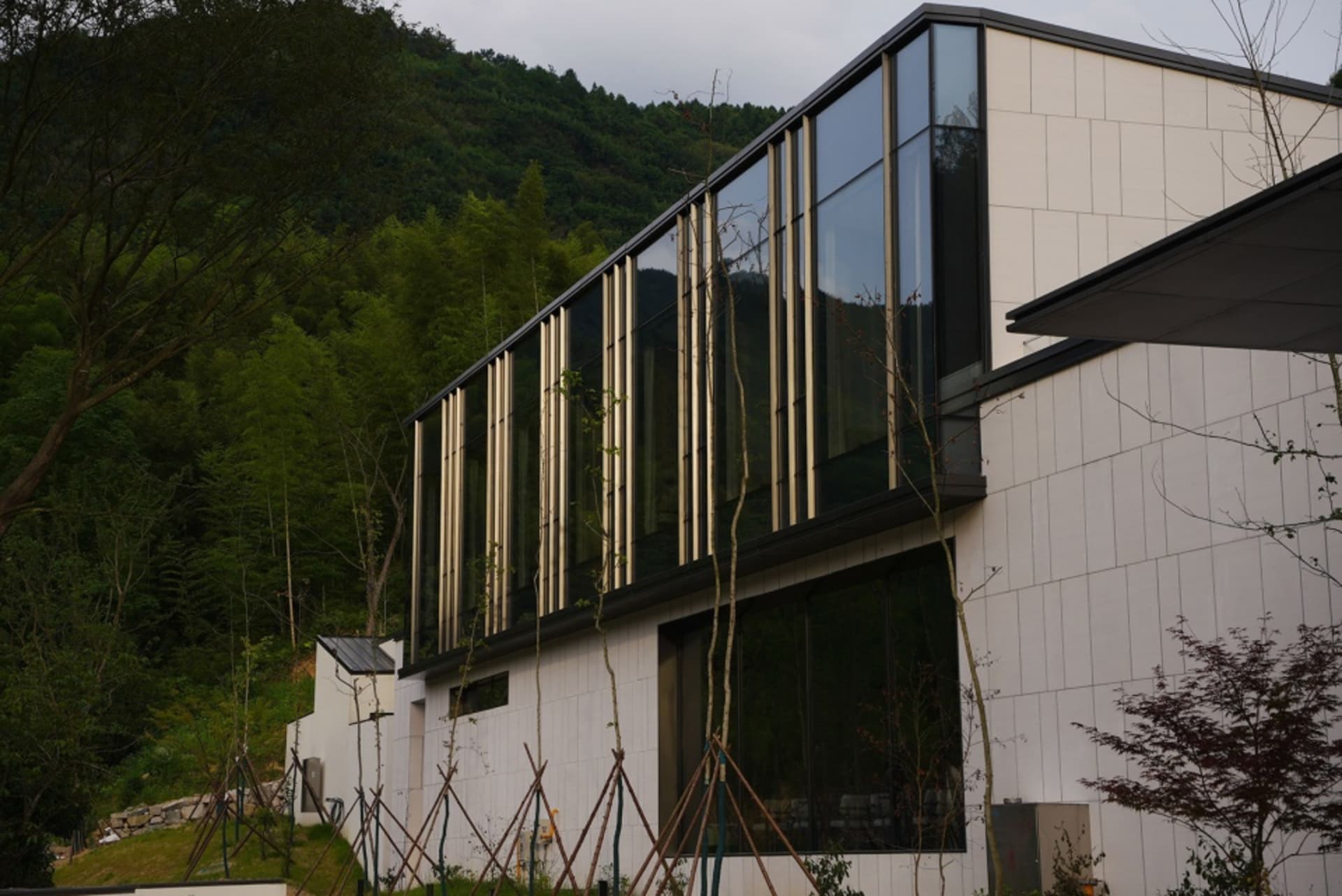 一座採用玻璃與混凝土材質的現代住宅建築。
