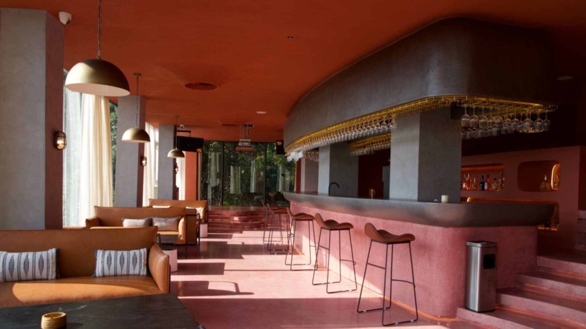 A modern bar interior featuring sleek concrete and glass materials.