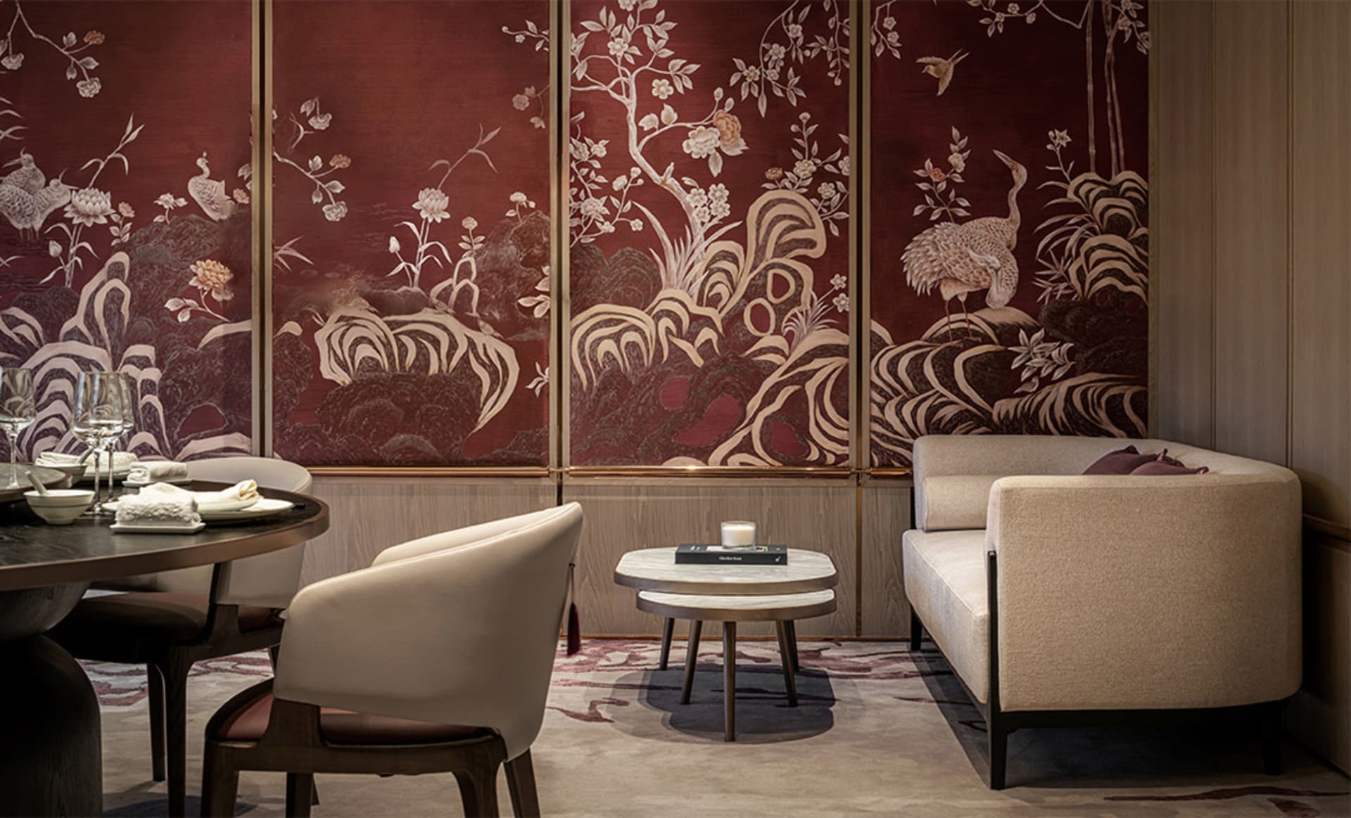現代餐廳室內,配有白色餐椅、米色沙發,以及圓形餐桌,桌上擺放餐盤、玻璃杯和毛巾