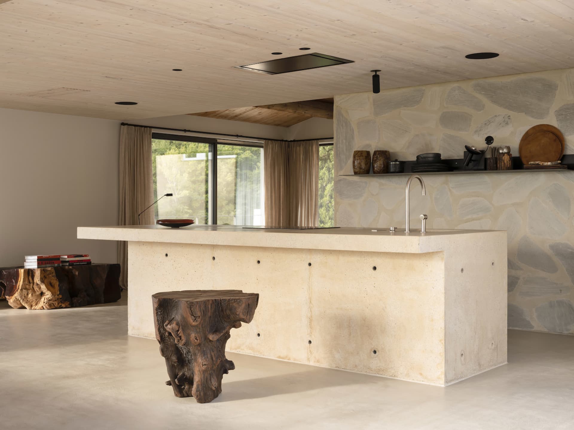 A modern kitchen featuring a concrete island and minimalist design.