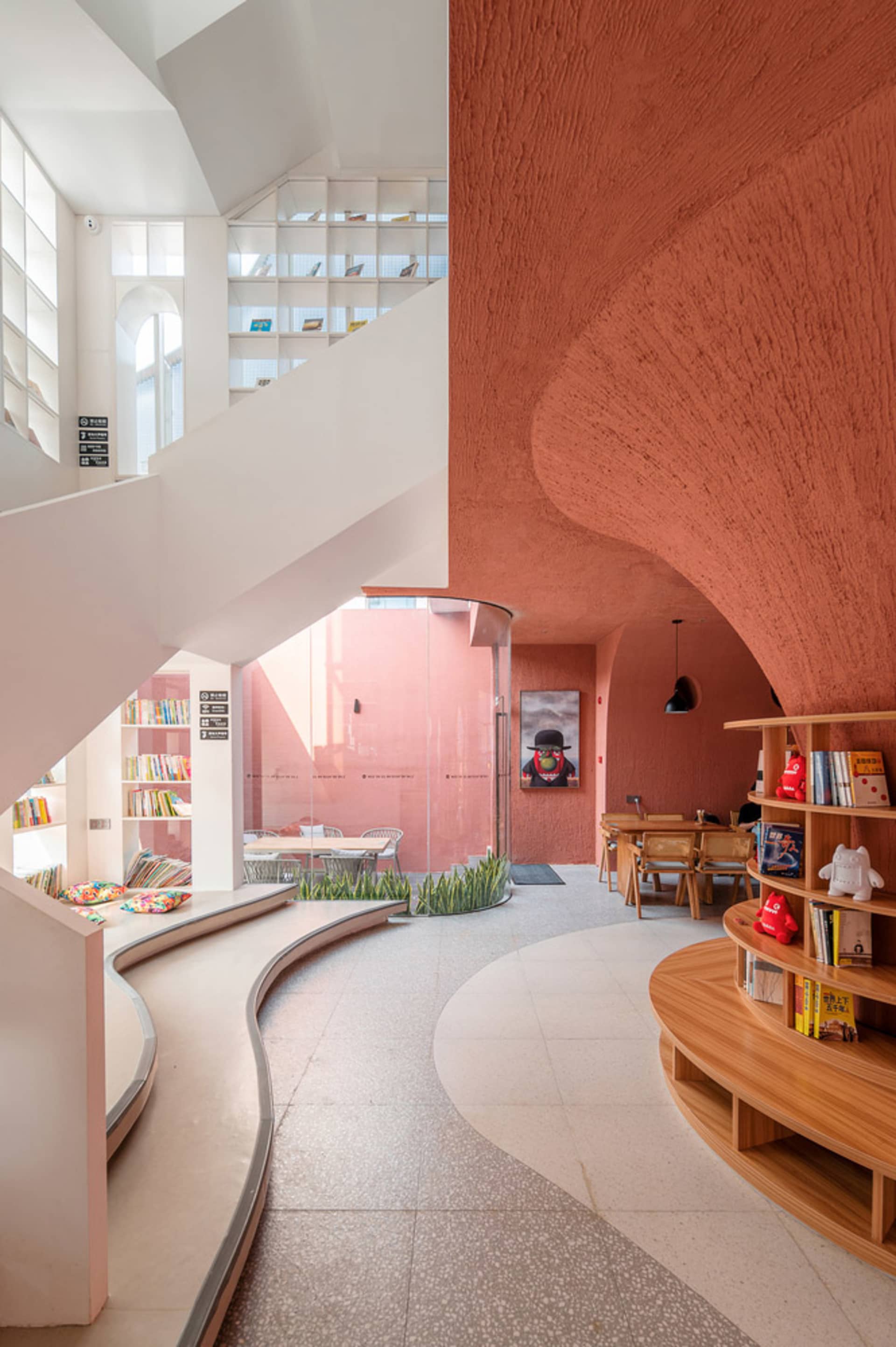 A modern library interior with wooden shelves and a curved seating area.