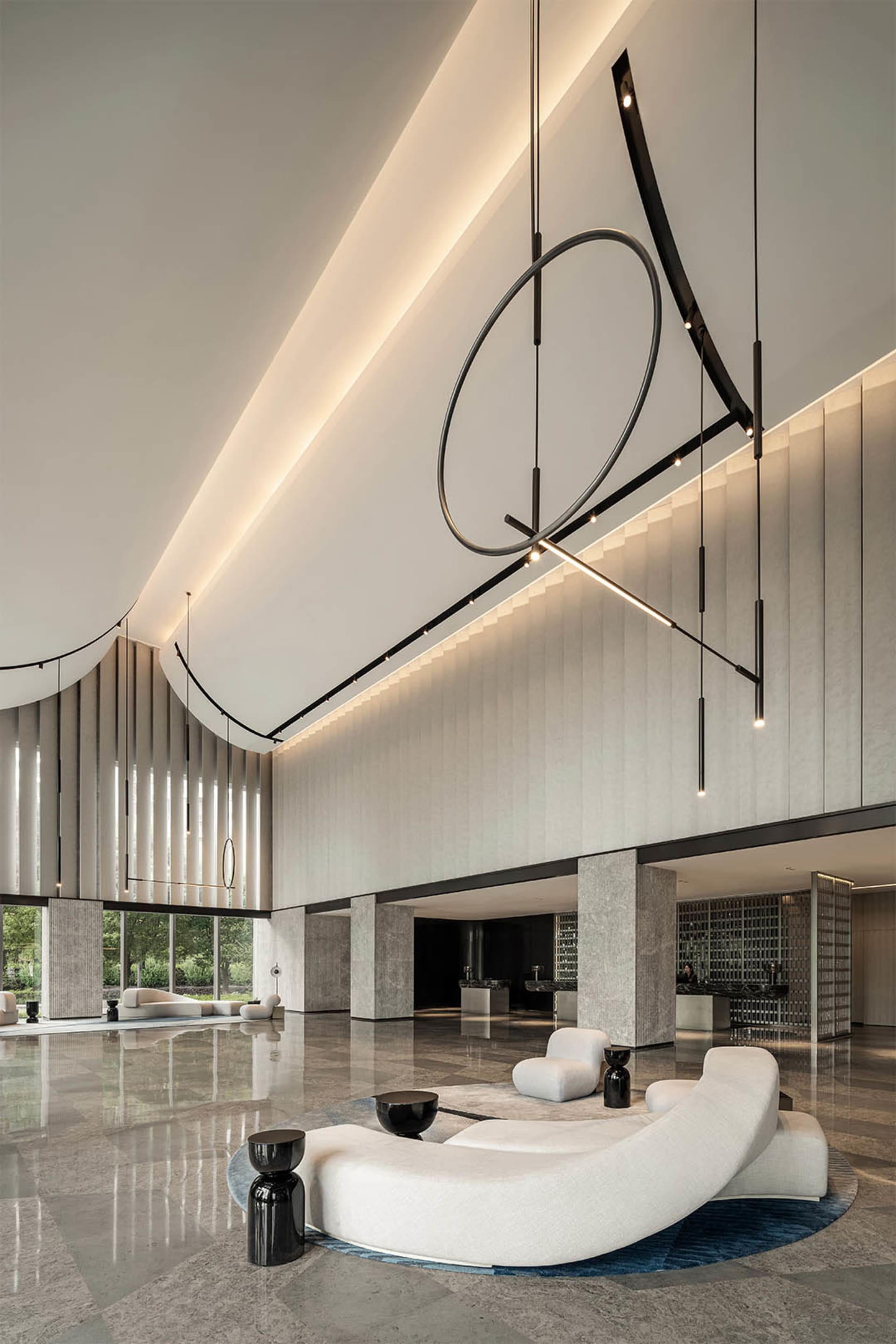 A modern lobby featuring sleek, minimalist design elements with concrete, glass, and metal finishes.