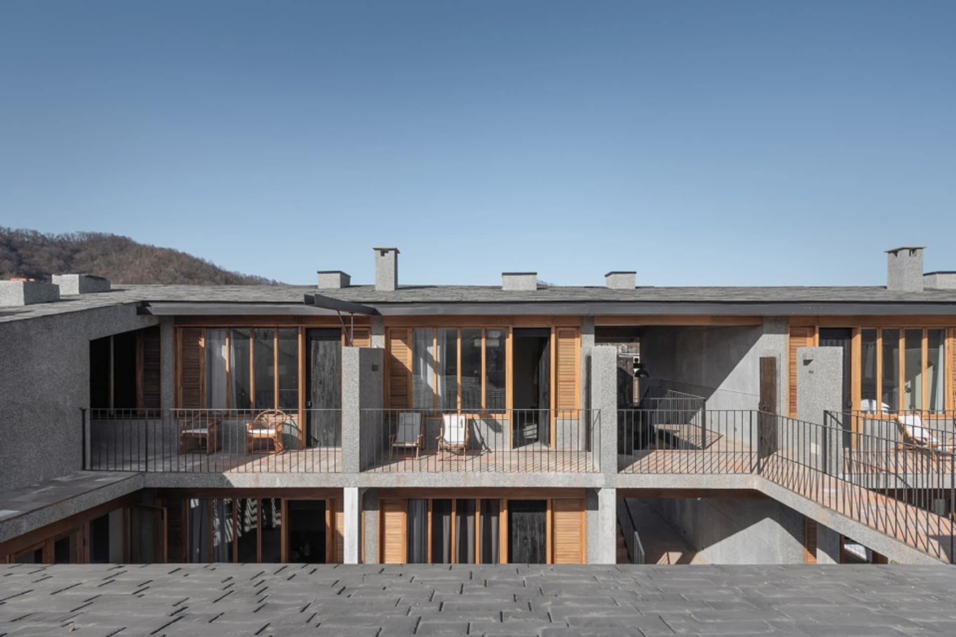 A modern residential building with concrete and wooden exterior.