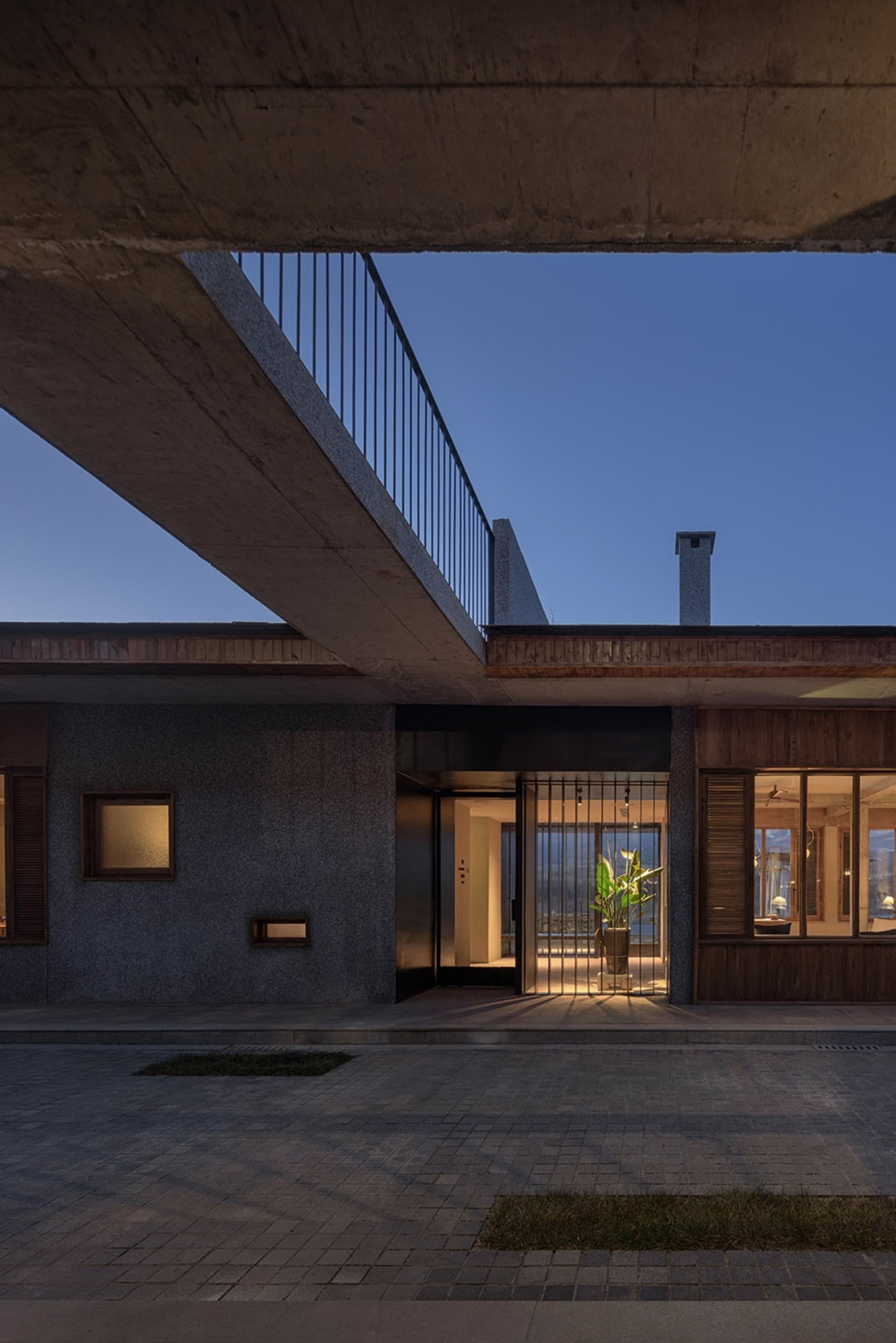 現代住宅建築採用清水混凝土外牆,入口處有燈光照明。