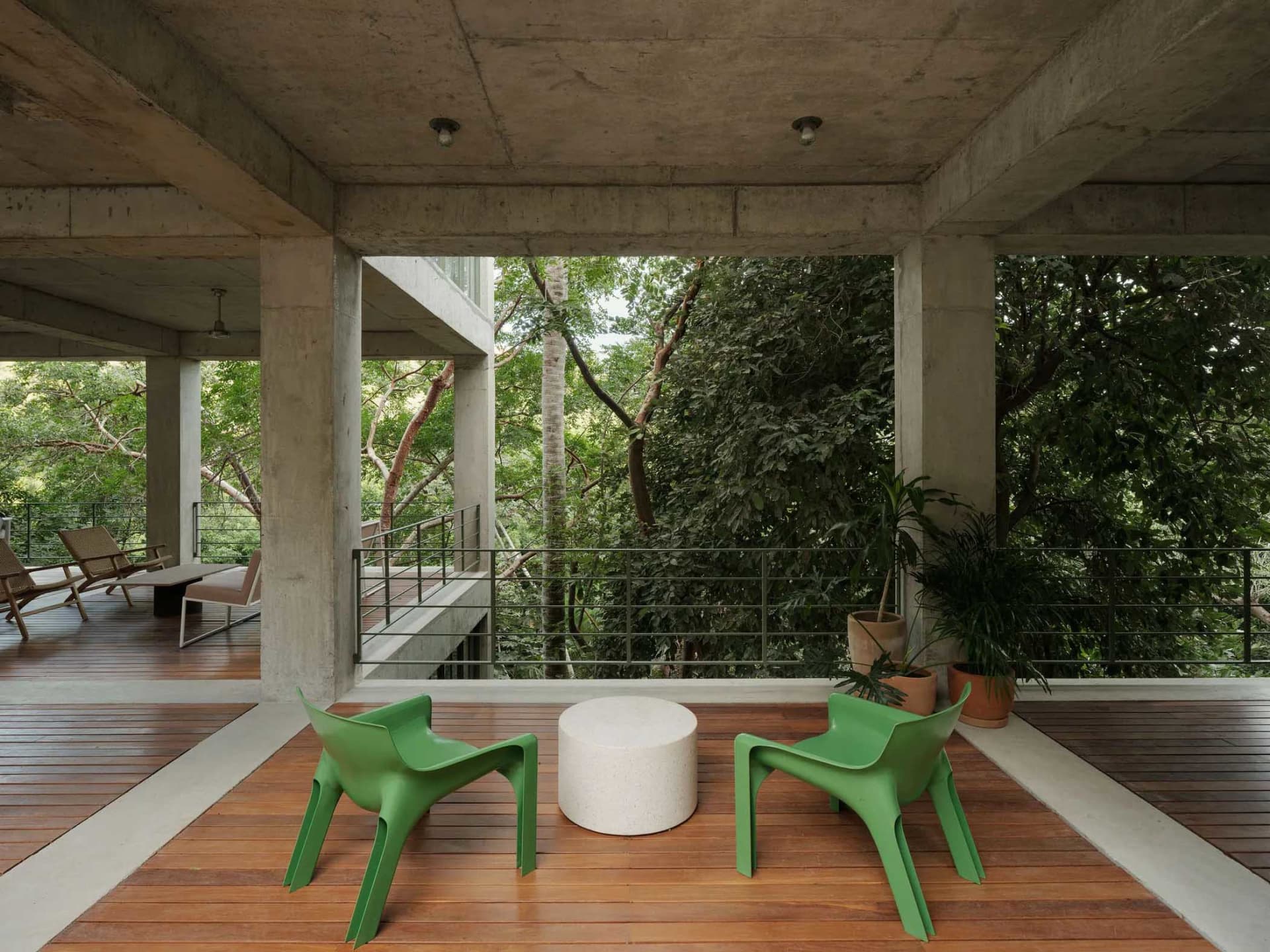 Modern veranda with green chairs and potted plants