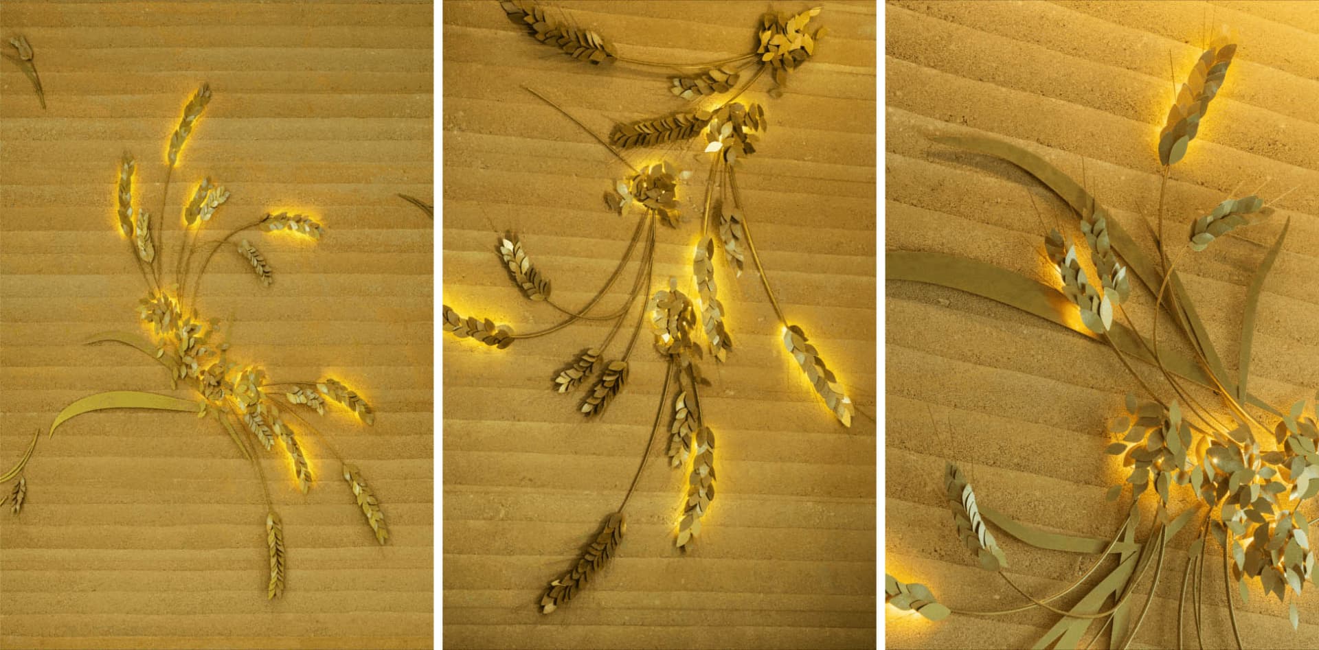 Metallic wheat decorations arranged in a minimalist design on a textured golden background.