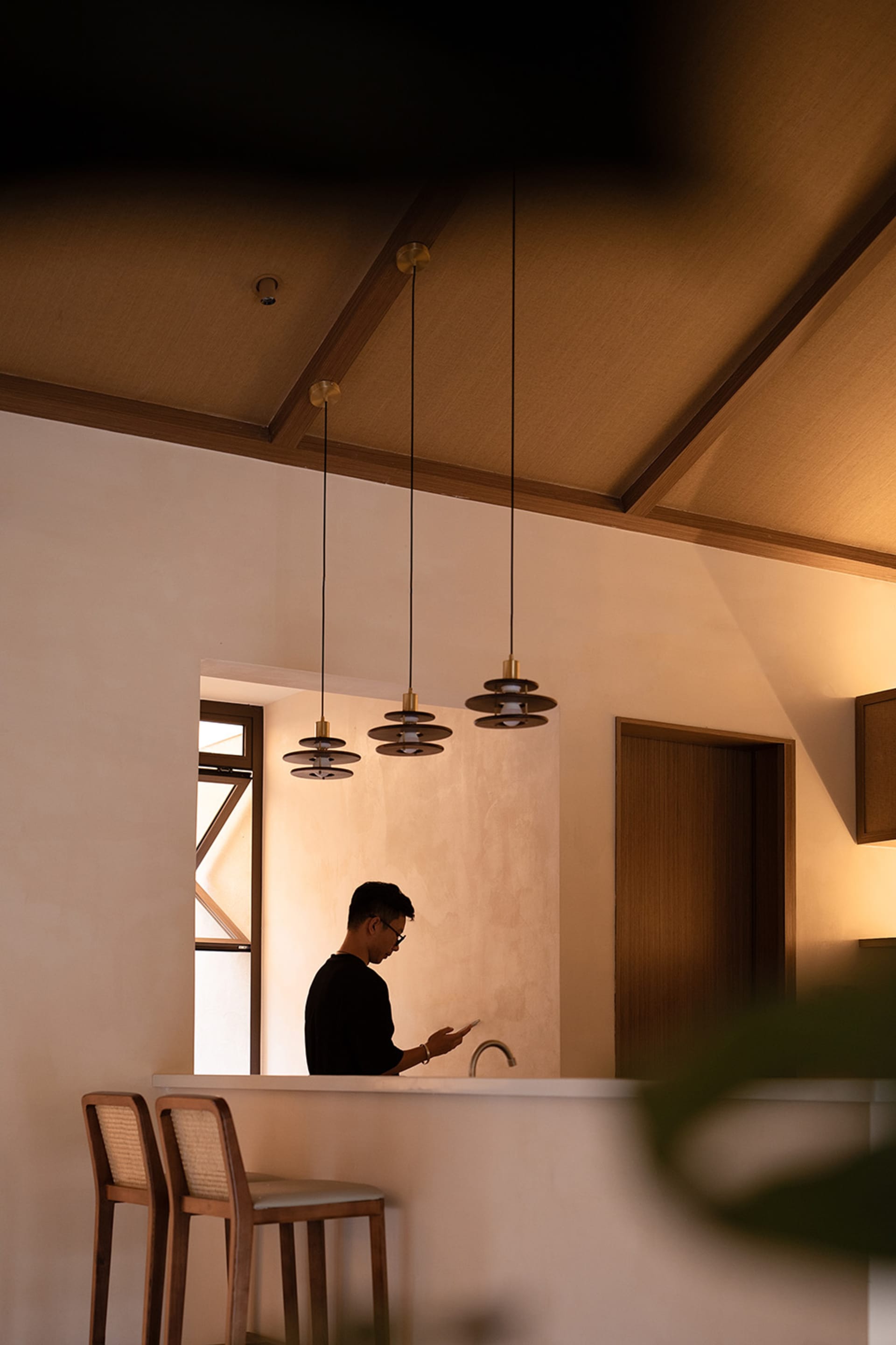A minimalist residential interior featuring concrete walls and wooden furniture.