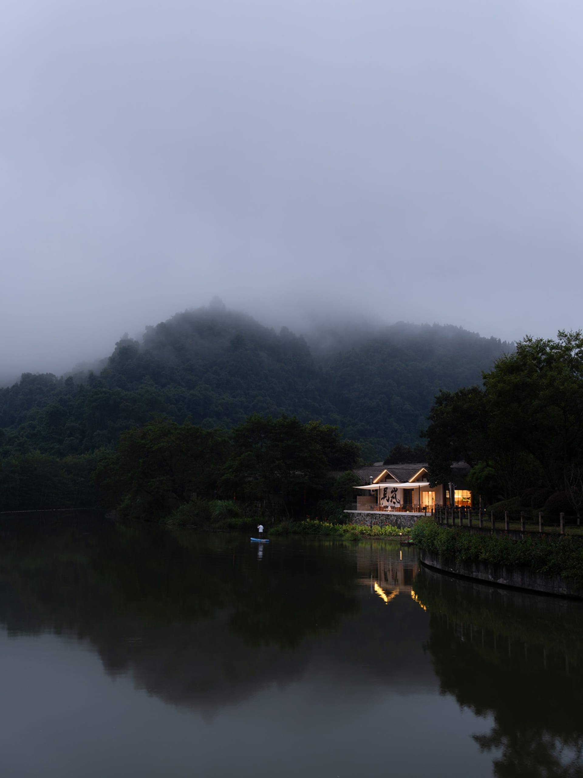 Minimalist architecture near a serene lake with natural surroundings.