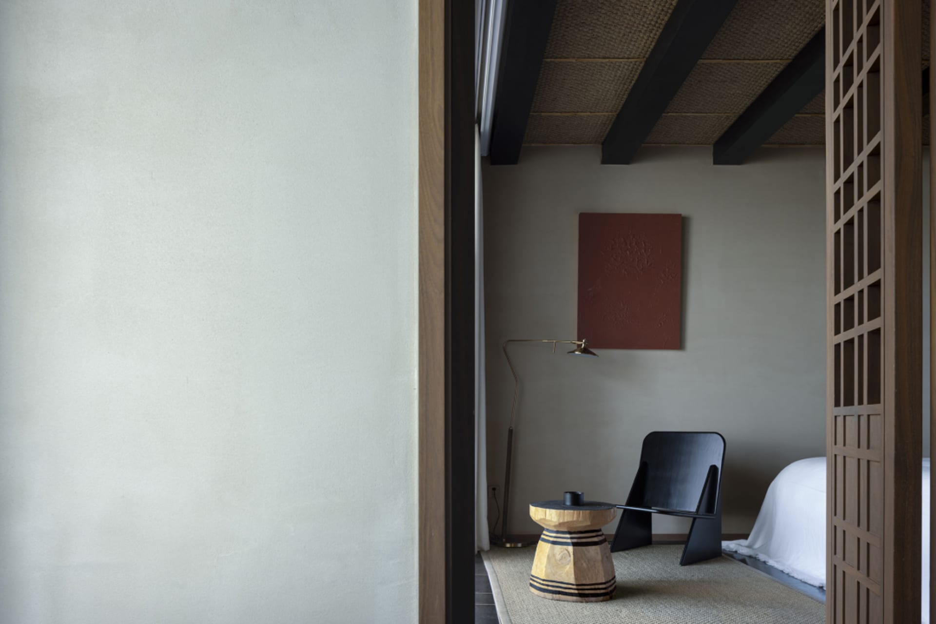 A modern bedroom featuring taupe textiles, wooden elements, and metal accents.