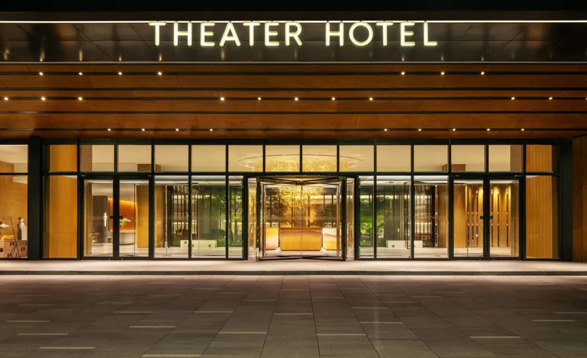 Modern building with glass and wooden materials and illuminated signage.