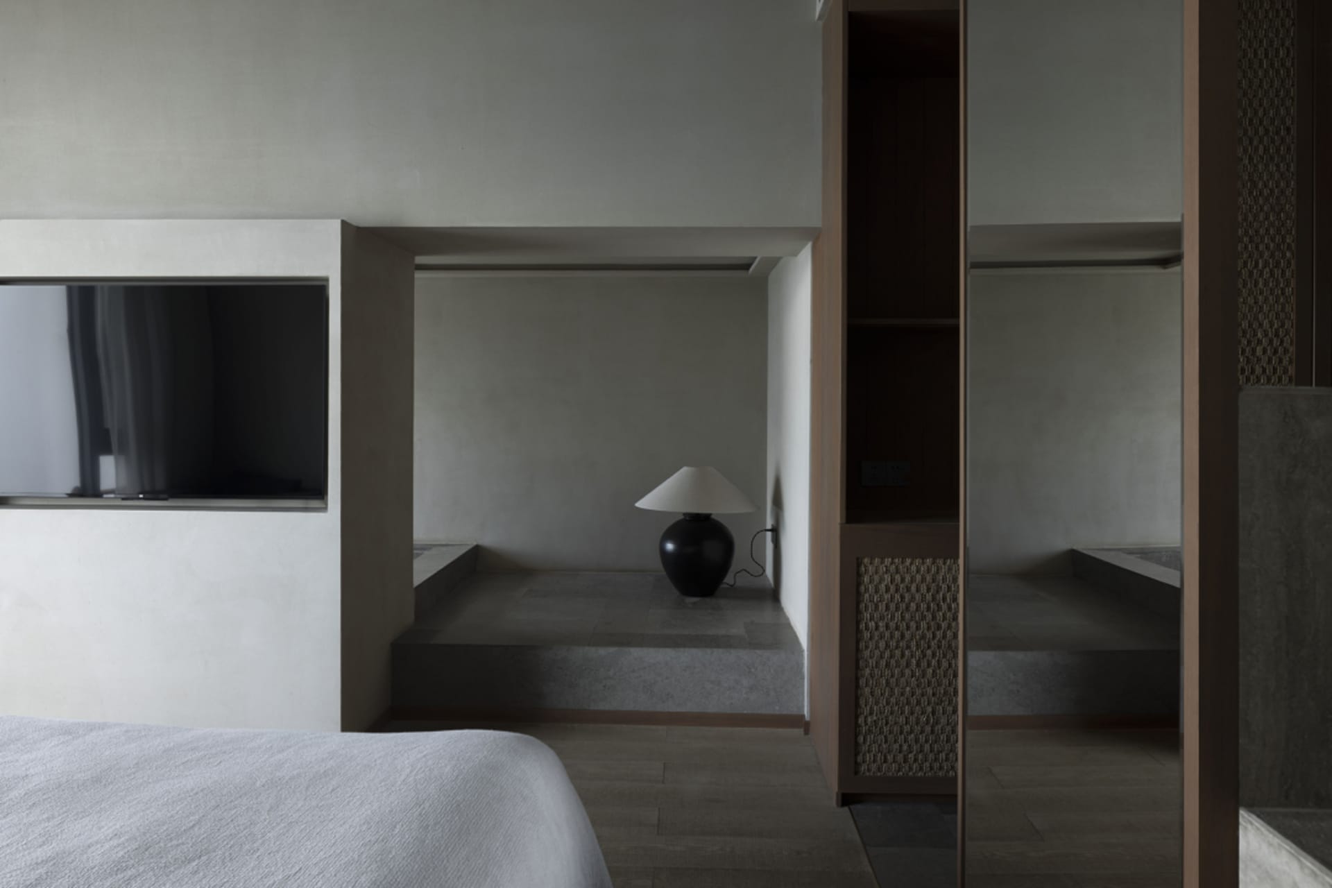 Minimalist bedroom with concrete floor and wood accents