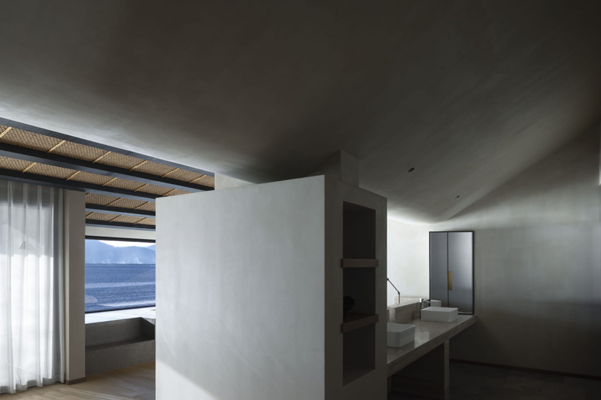 Modern residential bathroom with concrete walls, floor, and ceiling, featuring a minimalist design.