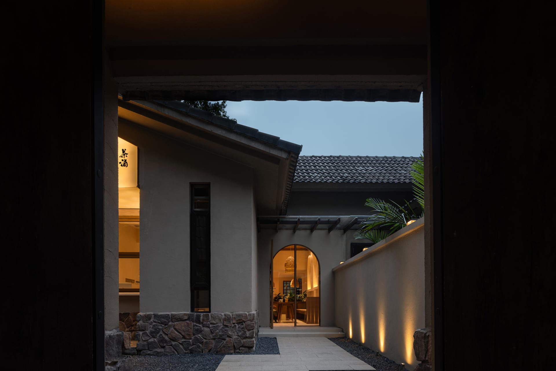A modern residential exterior featuring concrete and stone materials.