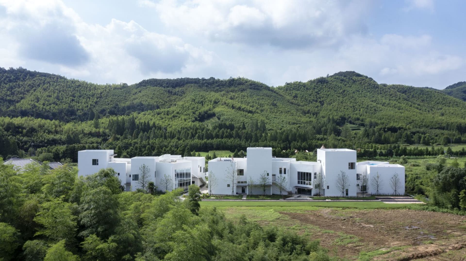 現代住宅建築，白色混凝土外觀搭配幾何設計。