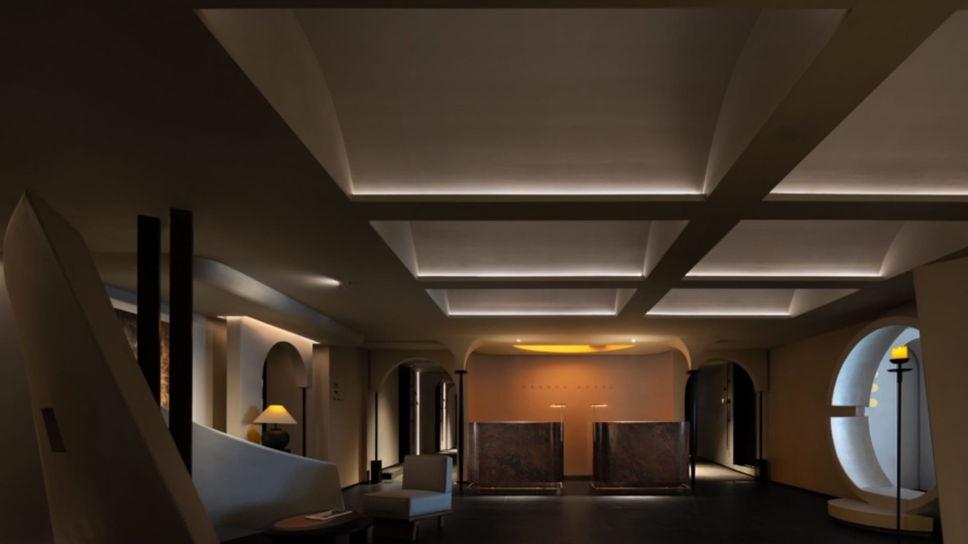 Modern lobby featuring concrete and marble finishes with a conference table.