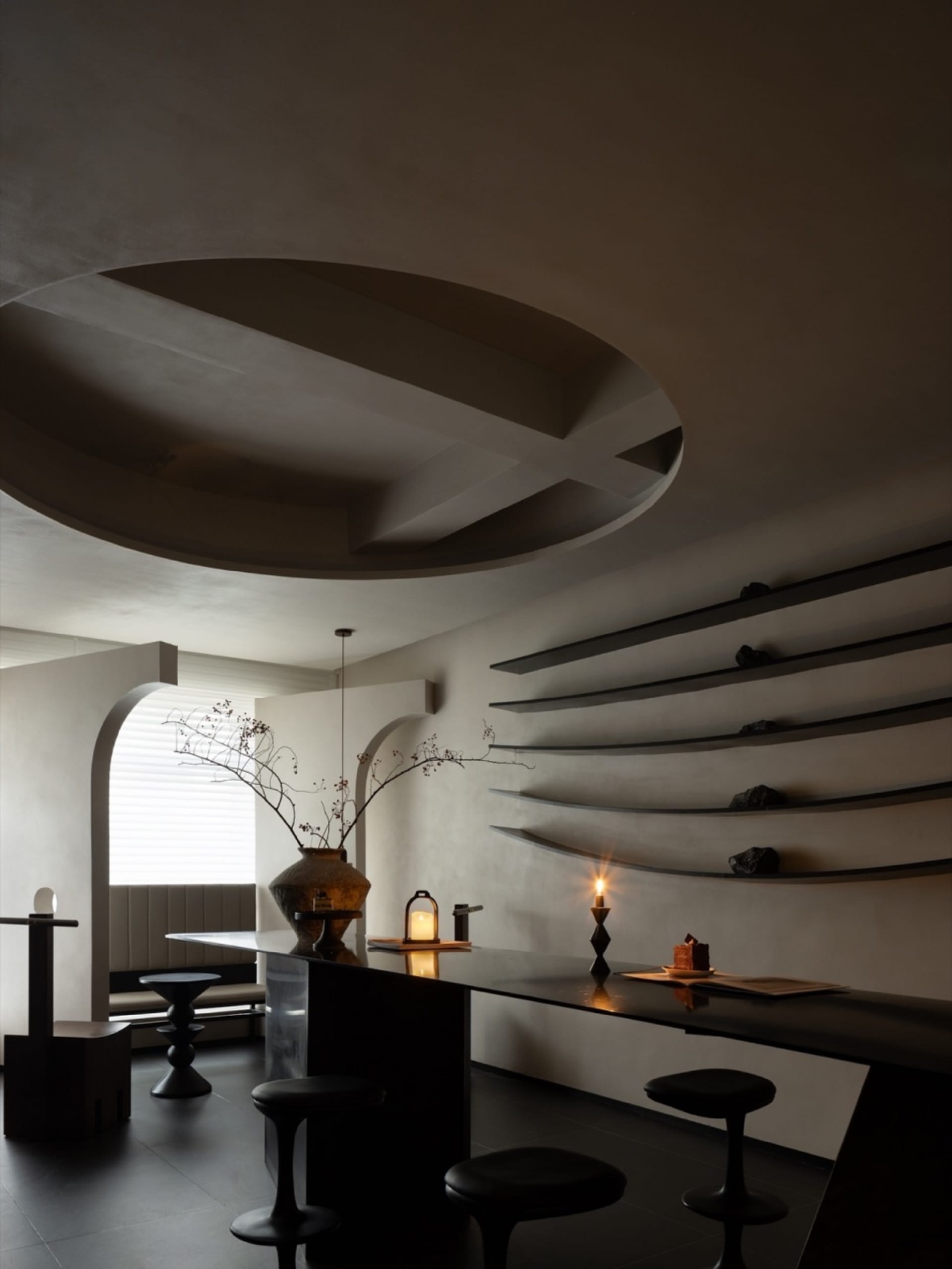 Modern bar with a black metal countertop and floating shelves.