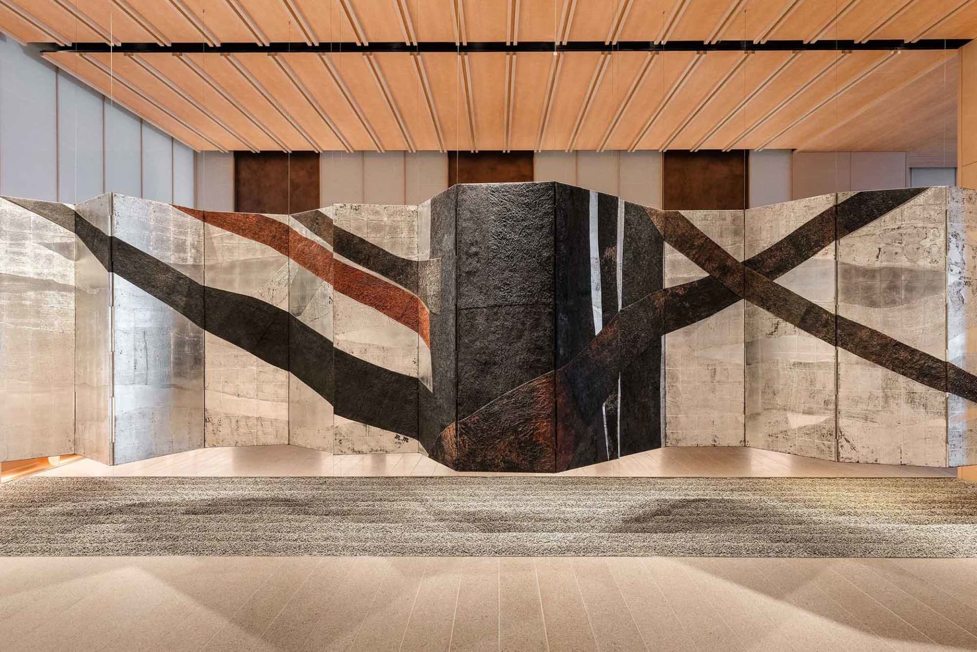 Modern lobby featuring decorative concrete, metallic accents, and leather textures.
