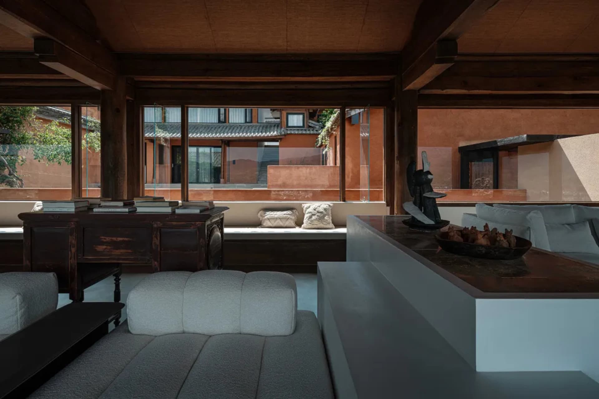 Modern living room with wooden furniture, large windows, and a comfortable seating area.