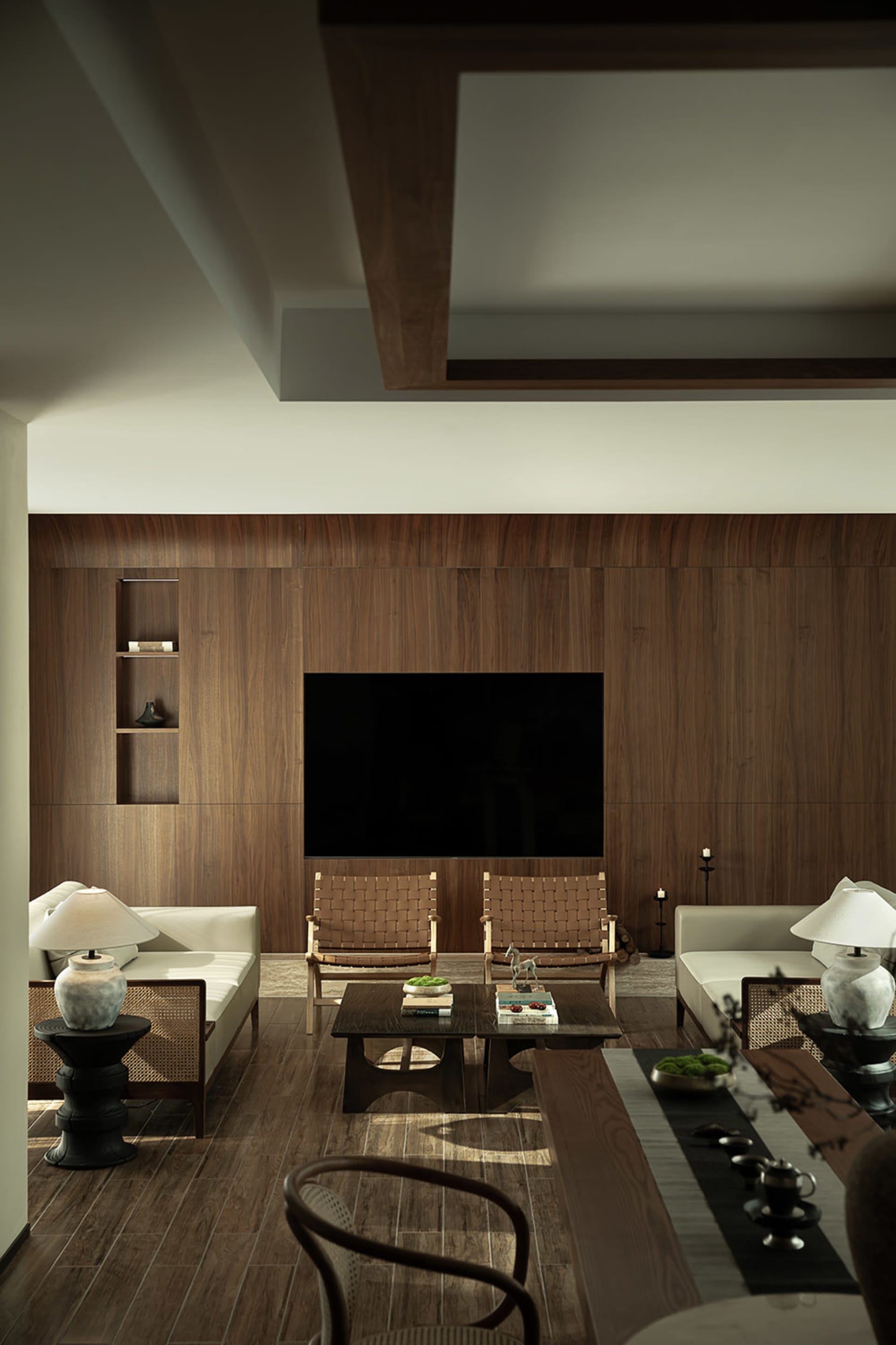 A minimalist living room with wooden furniture and a large wooden wall panel.