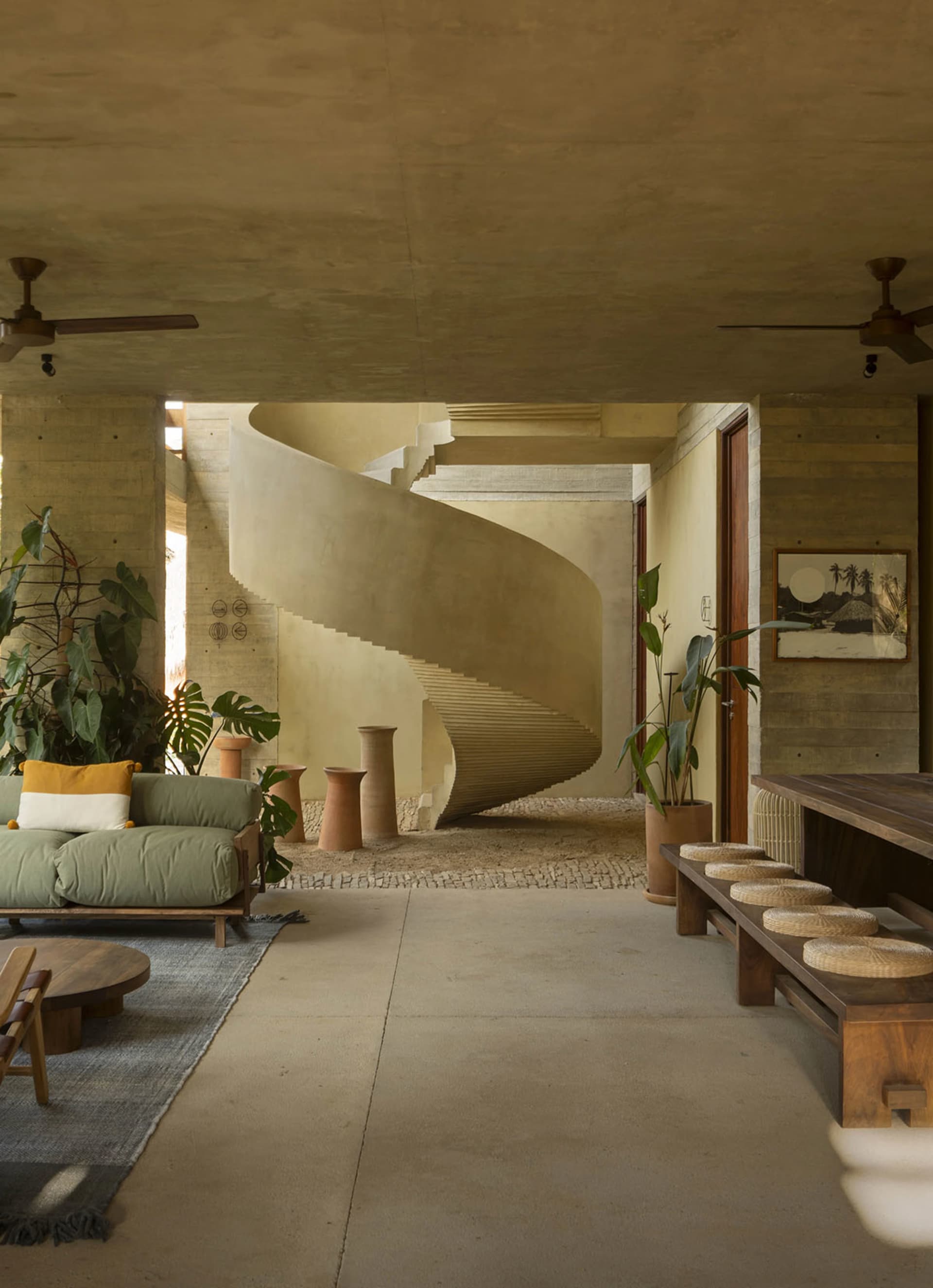 An industrial-style residential interior featuring a spiral staircase made of concrete.