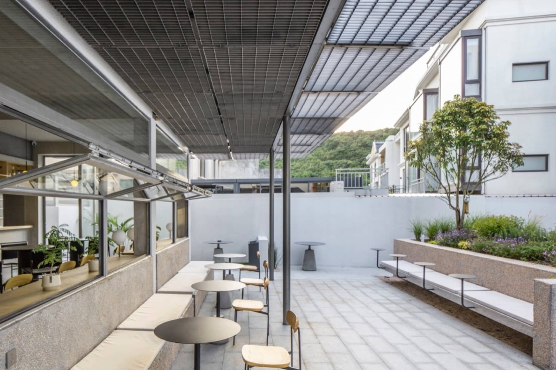 極簡自助餐廳,混凝土牆面、餐桌與座椅,搭配工業風家具與大型窗戶