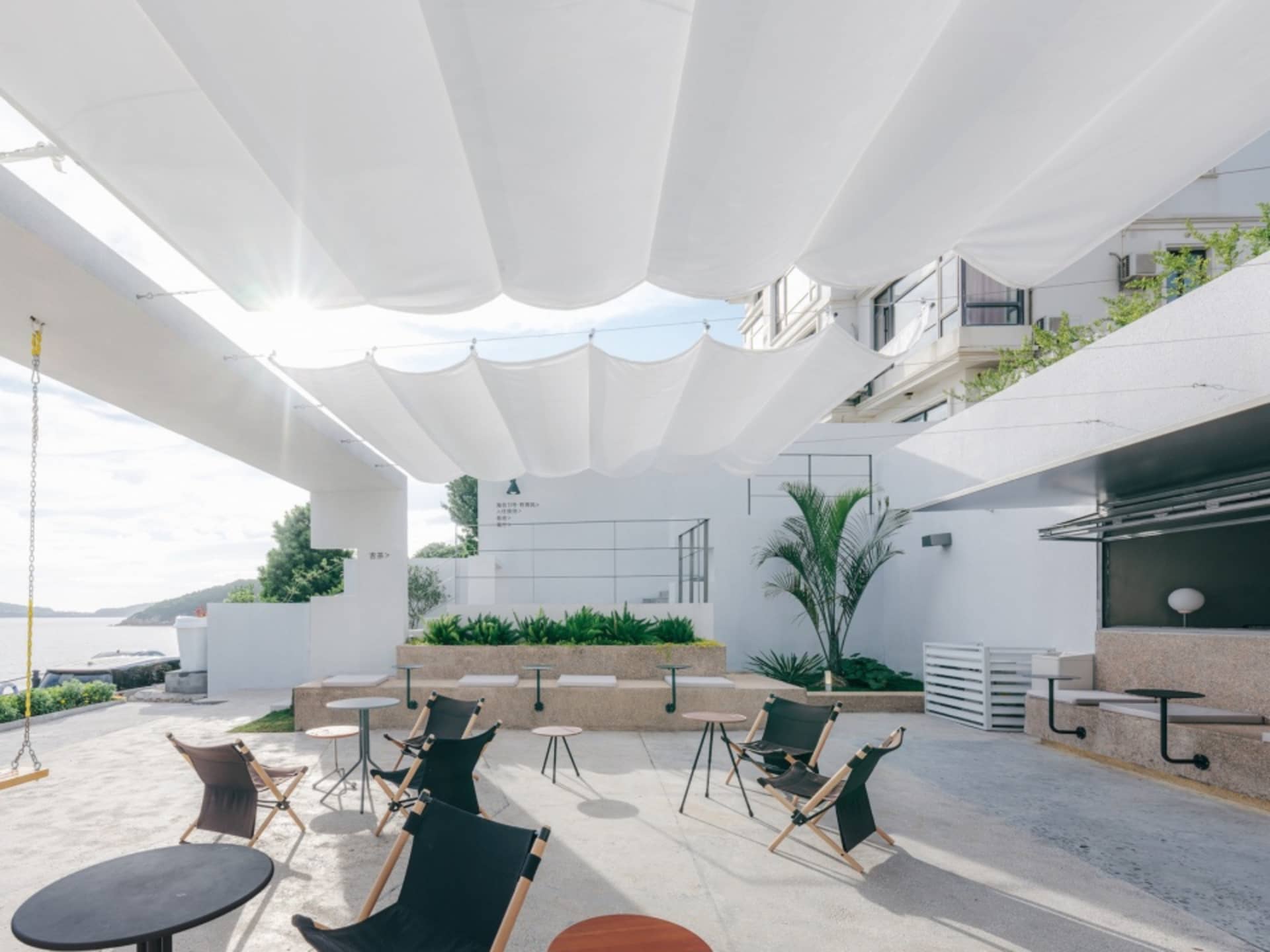 Minimalist outdoor seating area with concrete, metal, and fabric