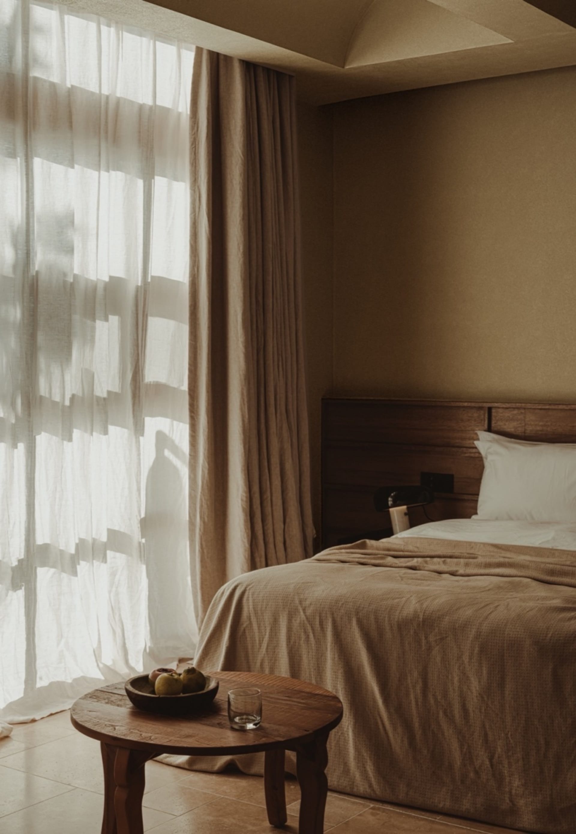 Modern bedroom with textured fabric, minimalistic style, large window, natural light, and wooden furniture.