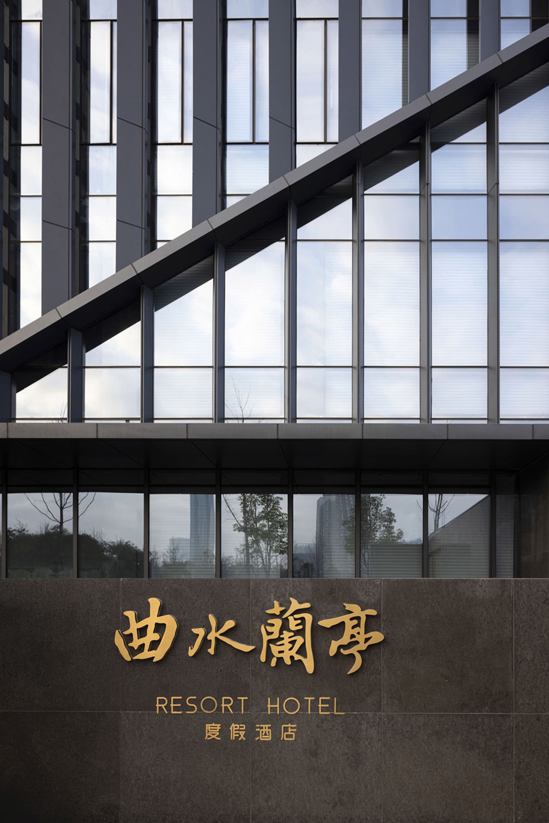 現代玻璃飯店外觀，擁有大型窗戶，並有「RESORT HOTEL」招牌。